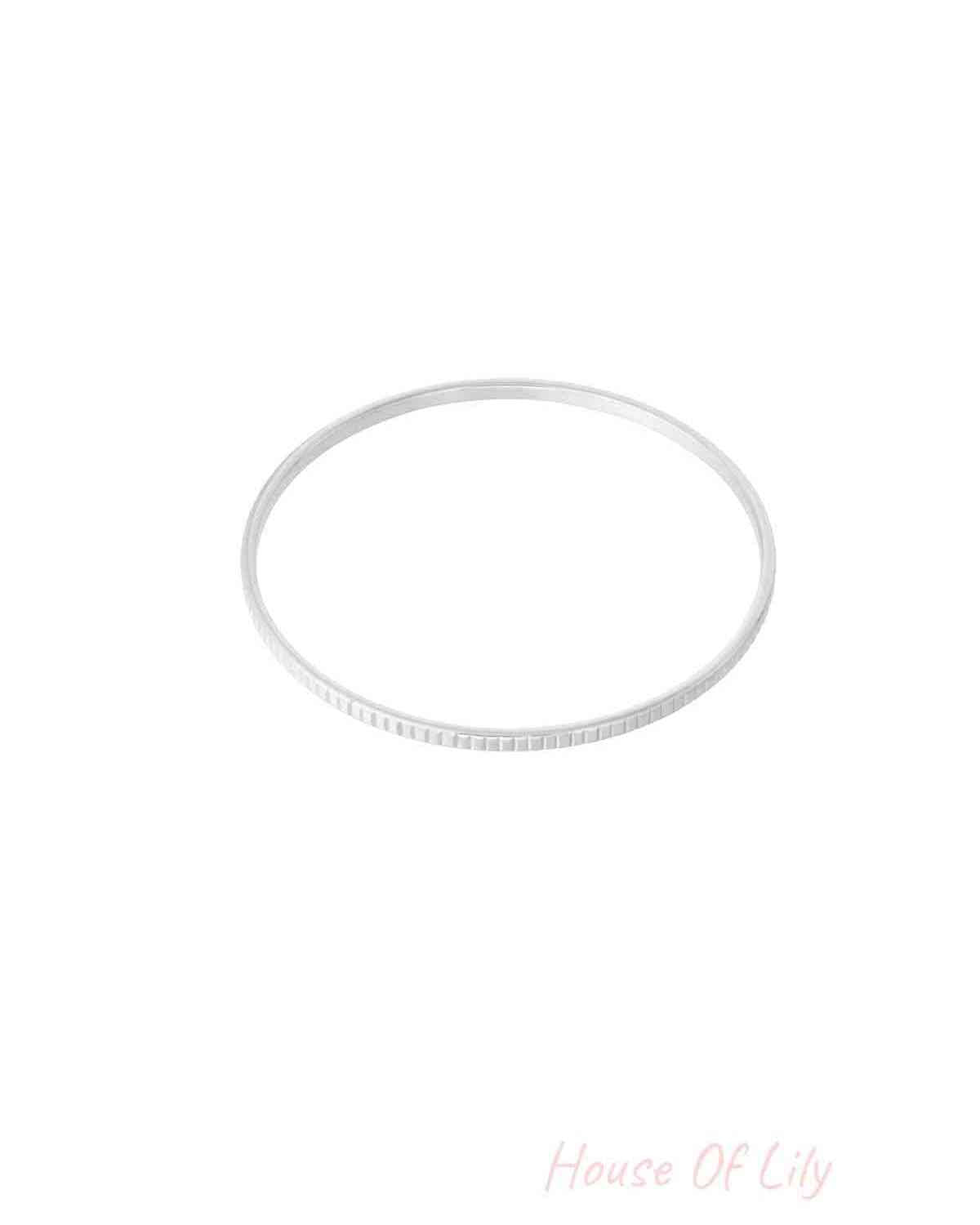 Sleek silver textured bangle bracelet isolated on white background