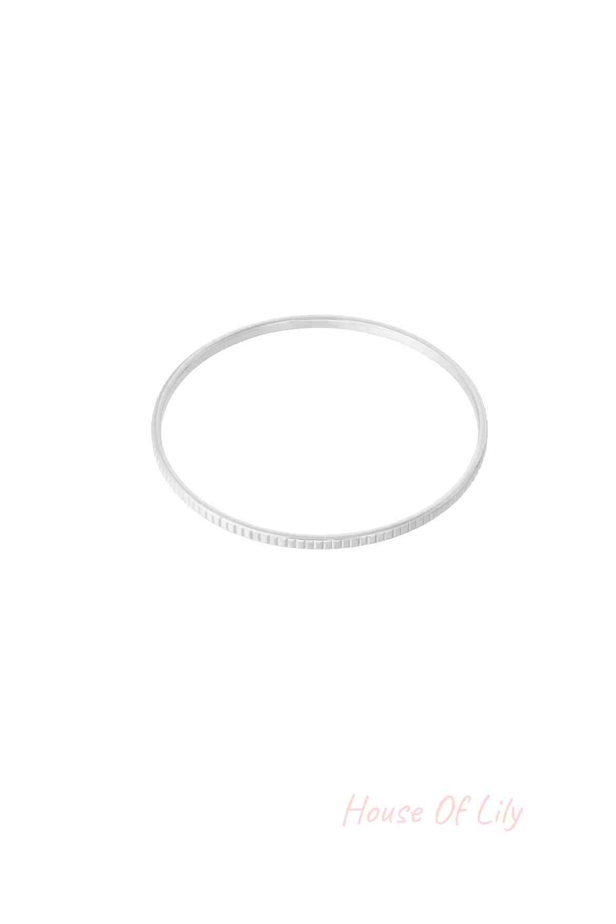 Sleek silver textured bangle bracelet isolated on white background