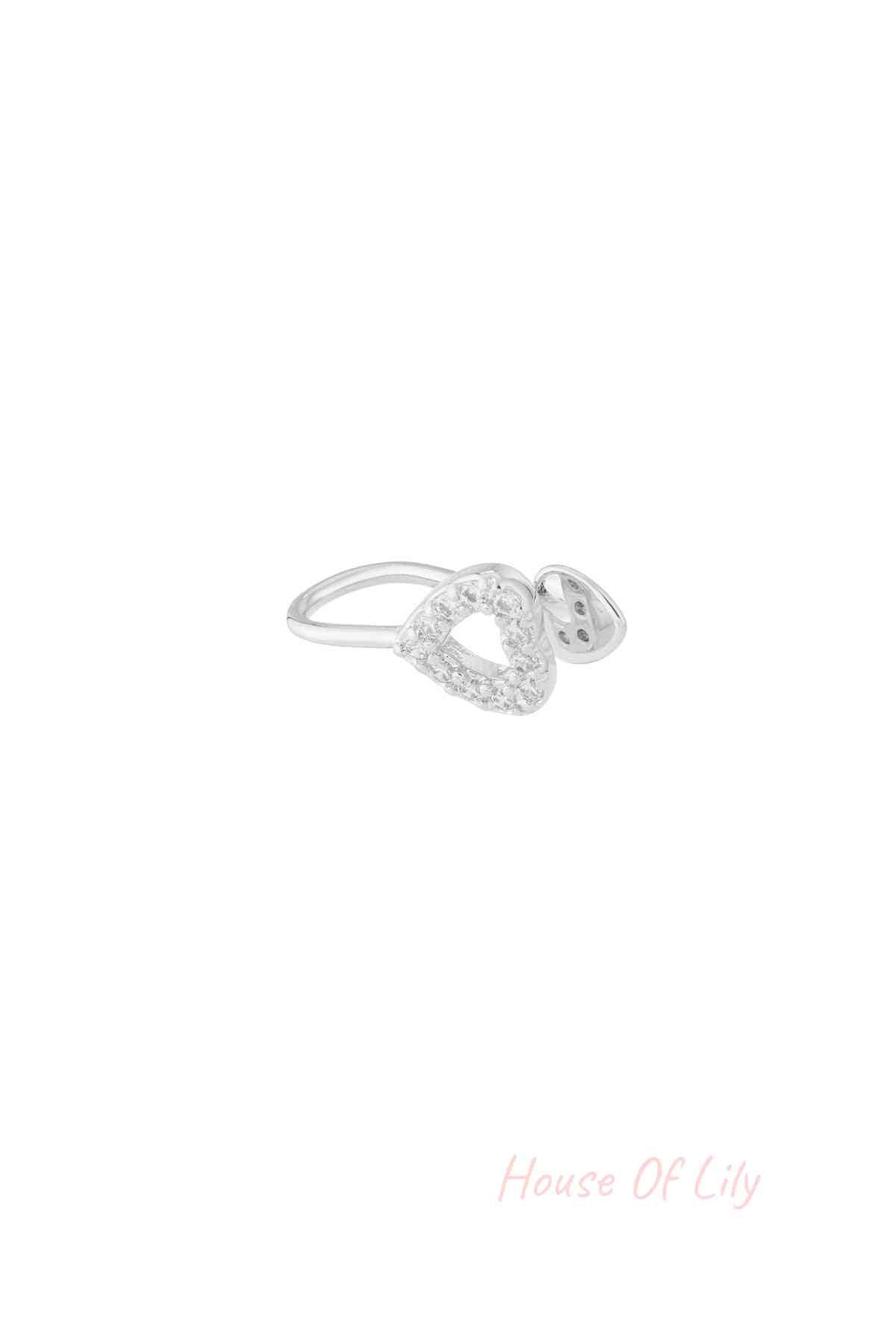Silver-tone heart-shaped ear cuff adorned with sparkling zircon crystals on white background