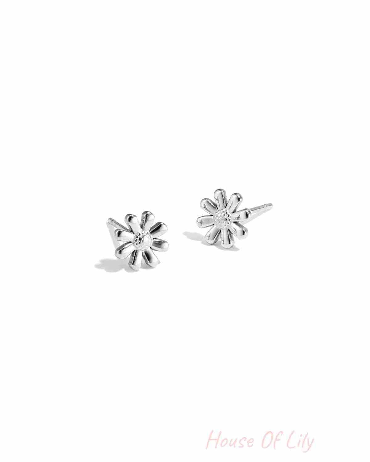 Pair of silver daisy flower stud earrings on white background