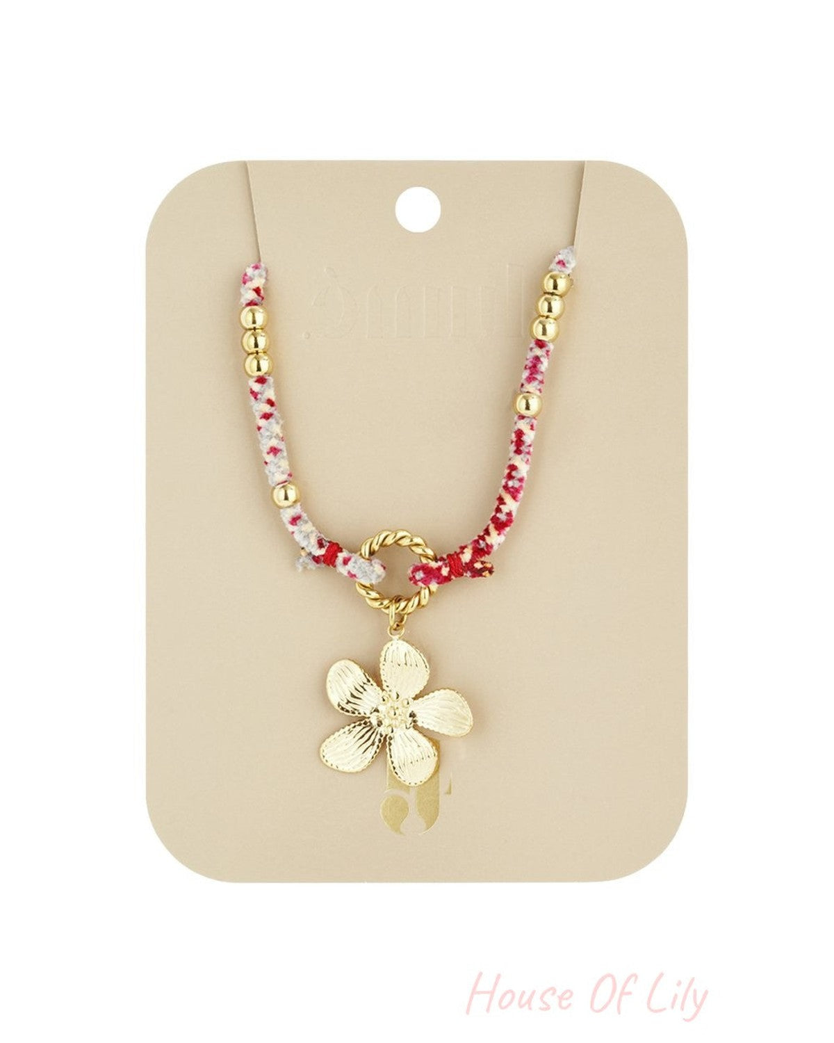 Chic Bloom Drop necklace features a gold flower charm on a pink/white cord with gold beads, on a beige display card.