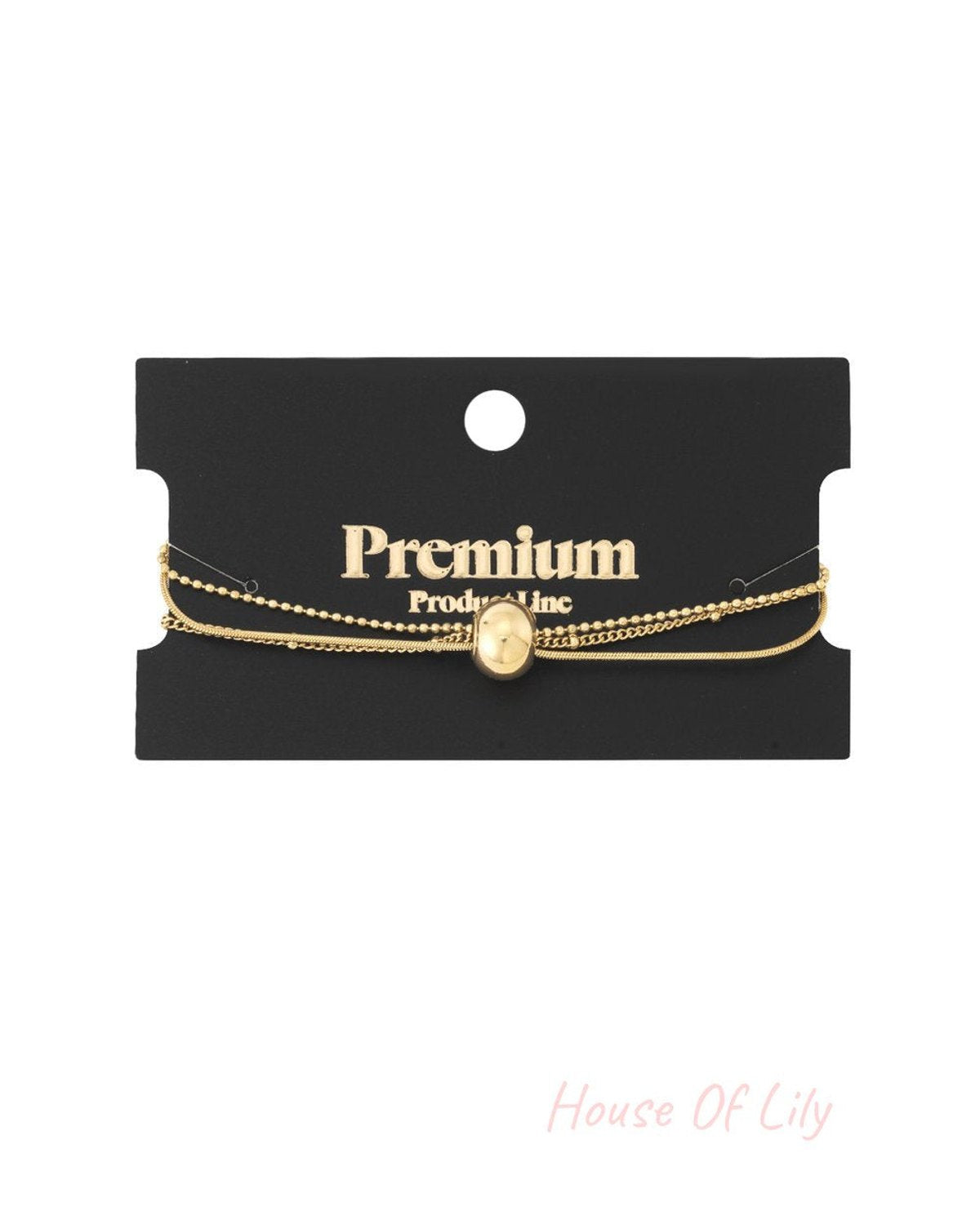 Elegant gold-tone multi-strand chain bracelet featuring a central polished spherical bead, displayed on a black card.