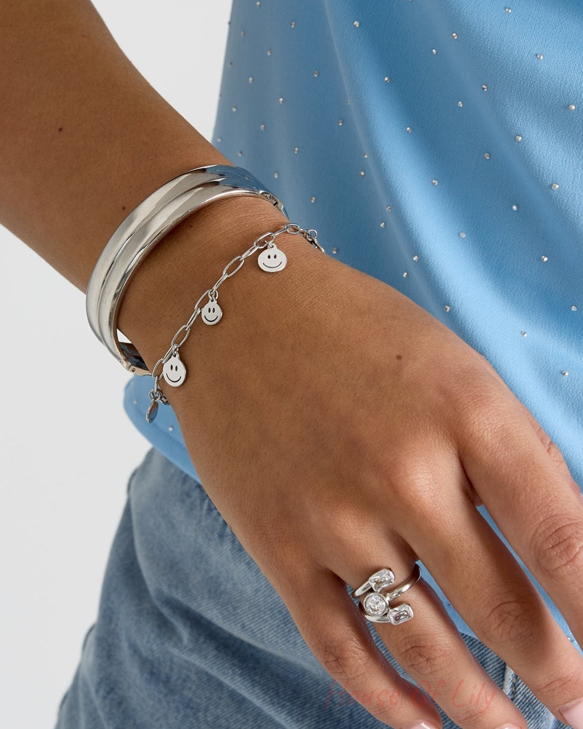 Happy Face Vibe: Silver charm bracelet with smiley faces, stacked with a sleek silver bangle and a modern crystal ring.