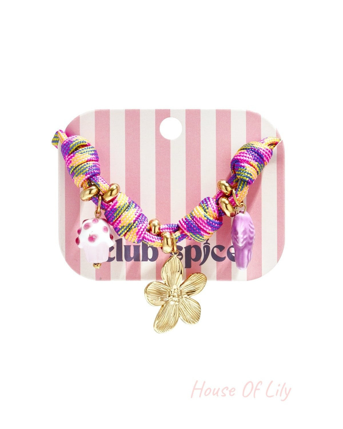 Close-up of multicolor rope charm bracelet with gold flower, cupcake and fish charms displayed on striped pink and white card
