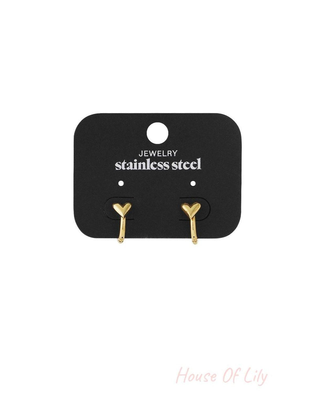 Gold-tone stainless steel heart-shaped hoop earrings on a black display card.