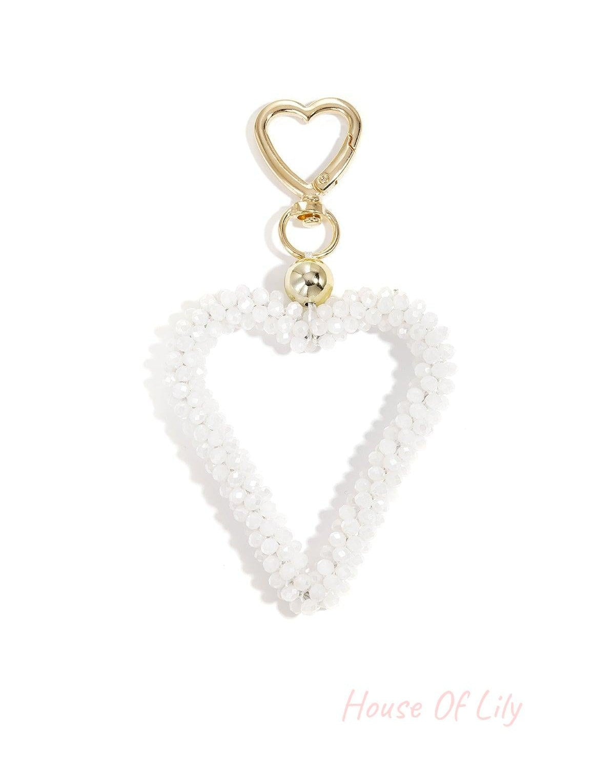 White beaded open heart keychain attached with gold hardware on white background