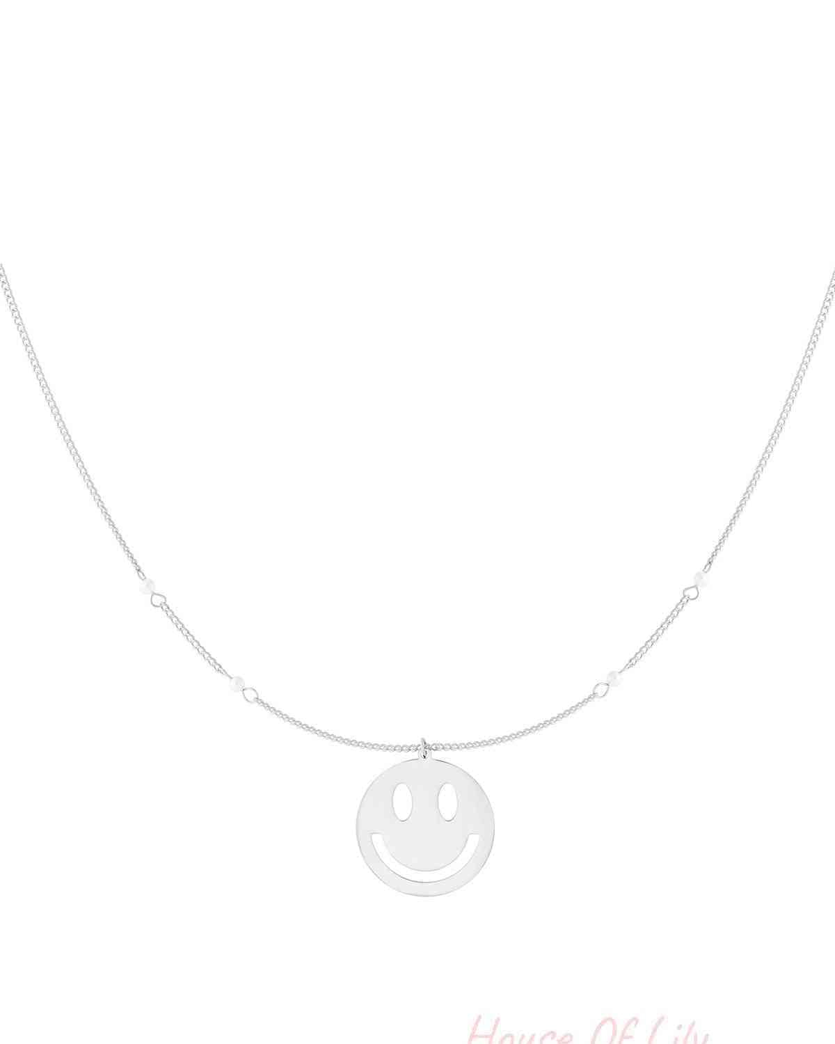 Silver version of the smiley face charm necklace featuring a delicate chain with small pearl accents