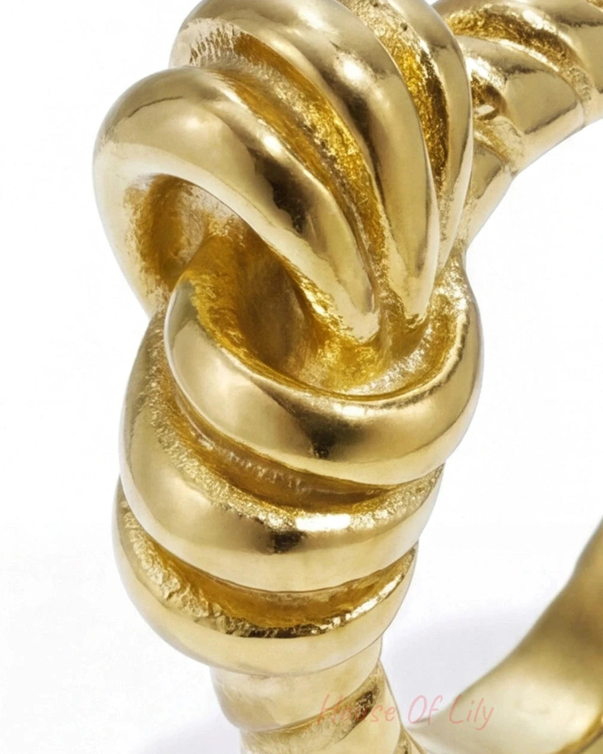 Close-up of a polished gold Ribbon Knot ring with a textured, intricate knotted design on a white background.