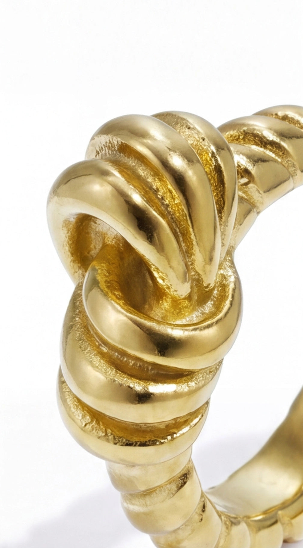 Close-up of a polished gold Ribbon Knot ring with a textured, intricate knotted design on a white background.