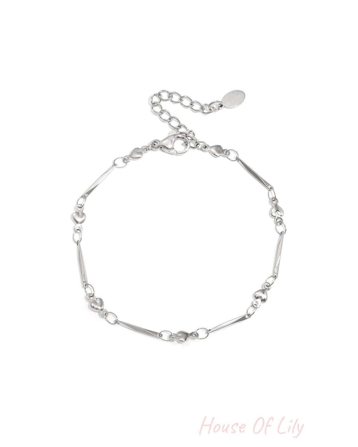 Close-up image of a delicate silver heart link bracelet with lobster clasp and adjustable chain on white background.