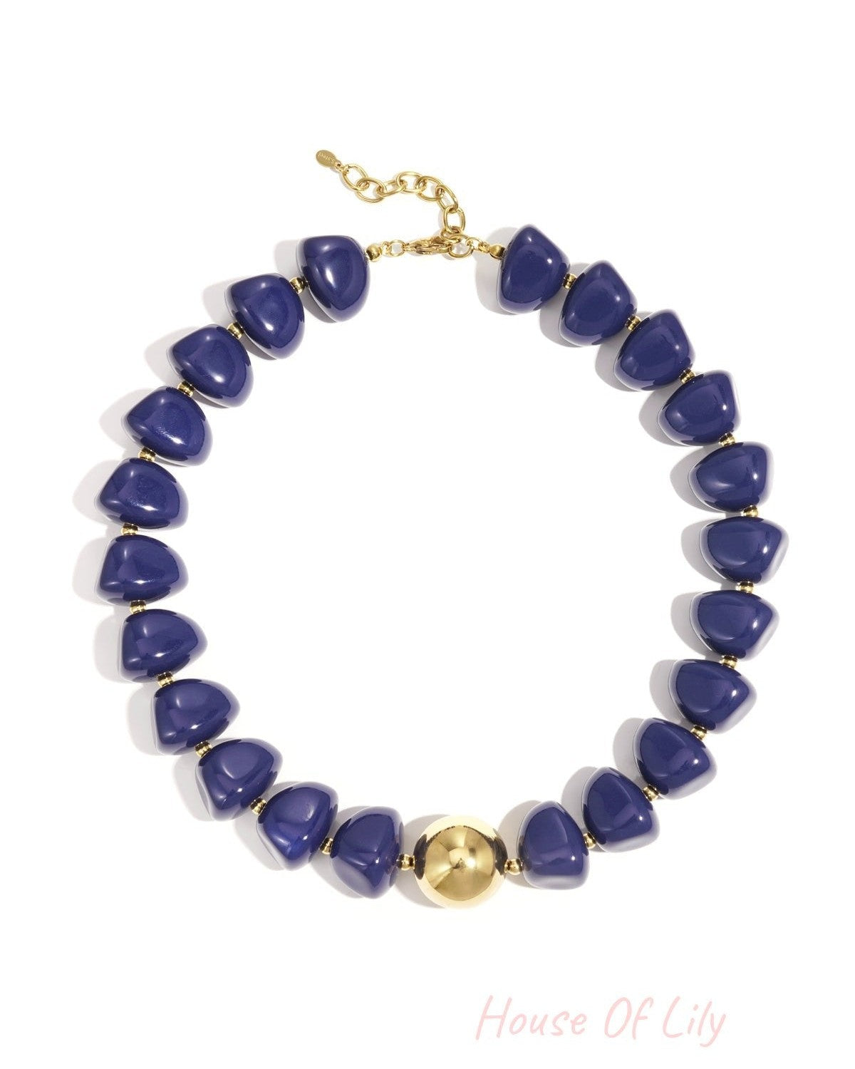 Close-up of a chunky blue beaded necklace with gold accent bead and clasp on white background