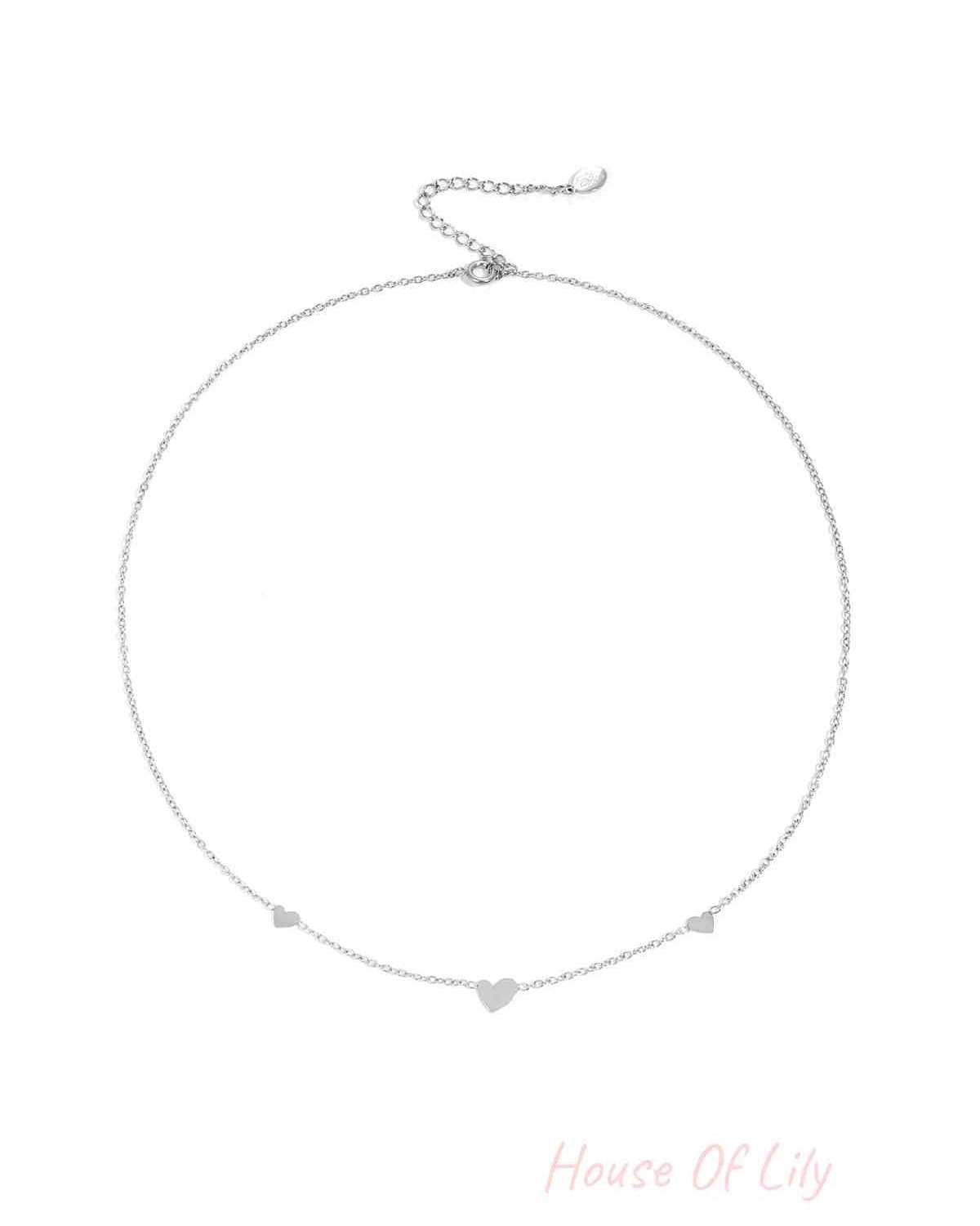 Silver heart charm chain necklace on white background