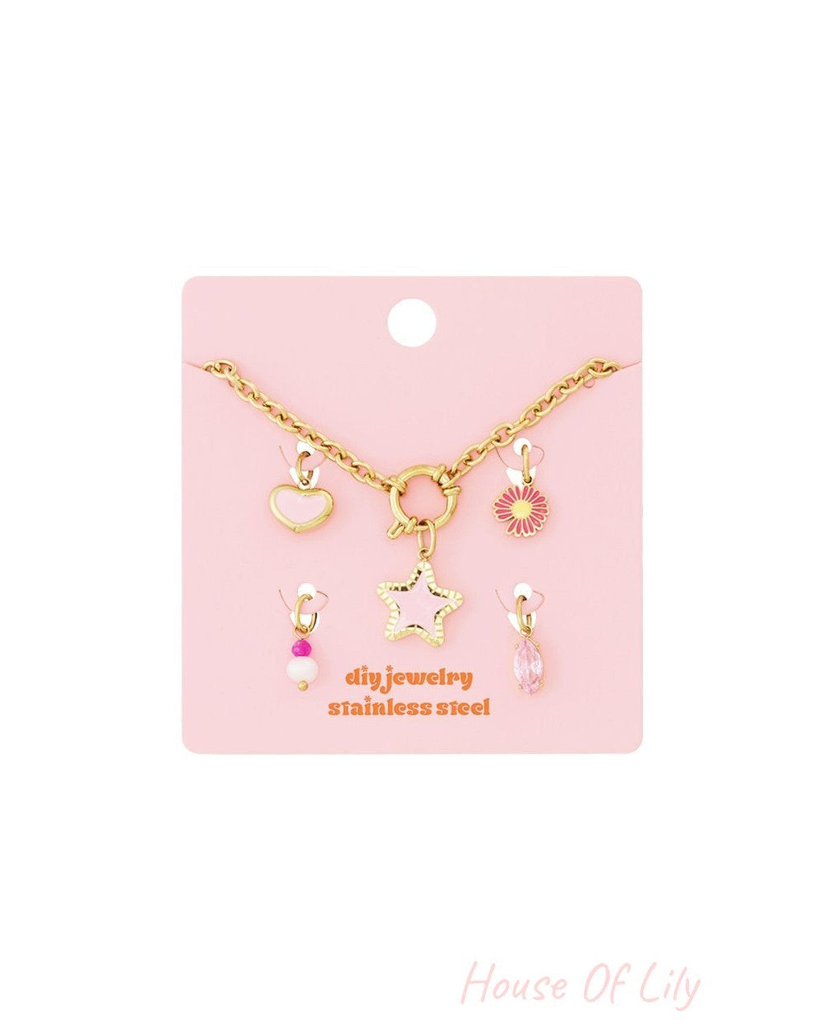 Whimsical gold stainless steel link bracelet on pink card, featuring star, heart, flower, and crystal charms.