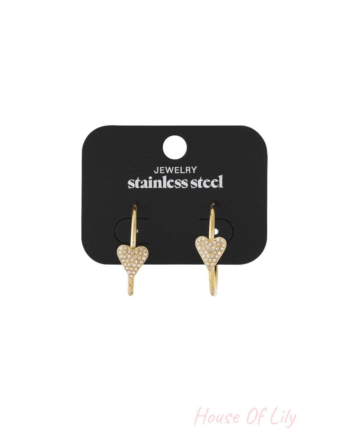 Gold-tone stainless steel hoop earrings featuring small heart-shaped charms embellished with sparkling clear crystals.