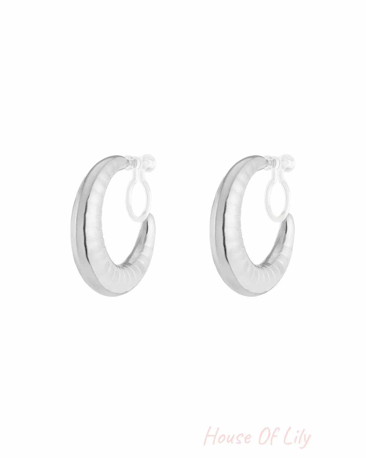 Pair of chunky silver clip-on hoop earrings with ripple texture on white background