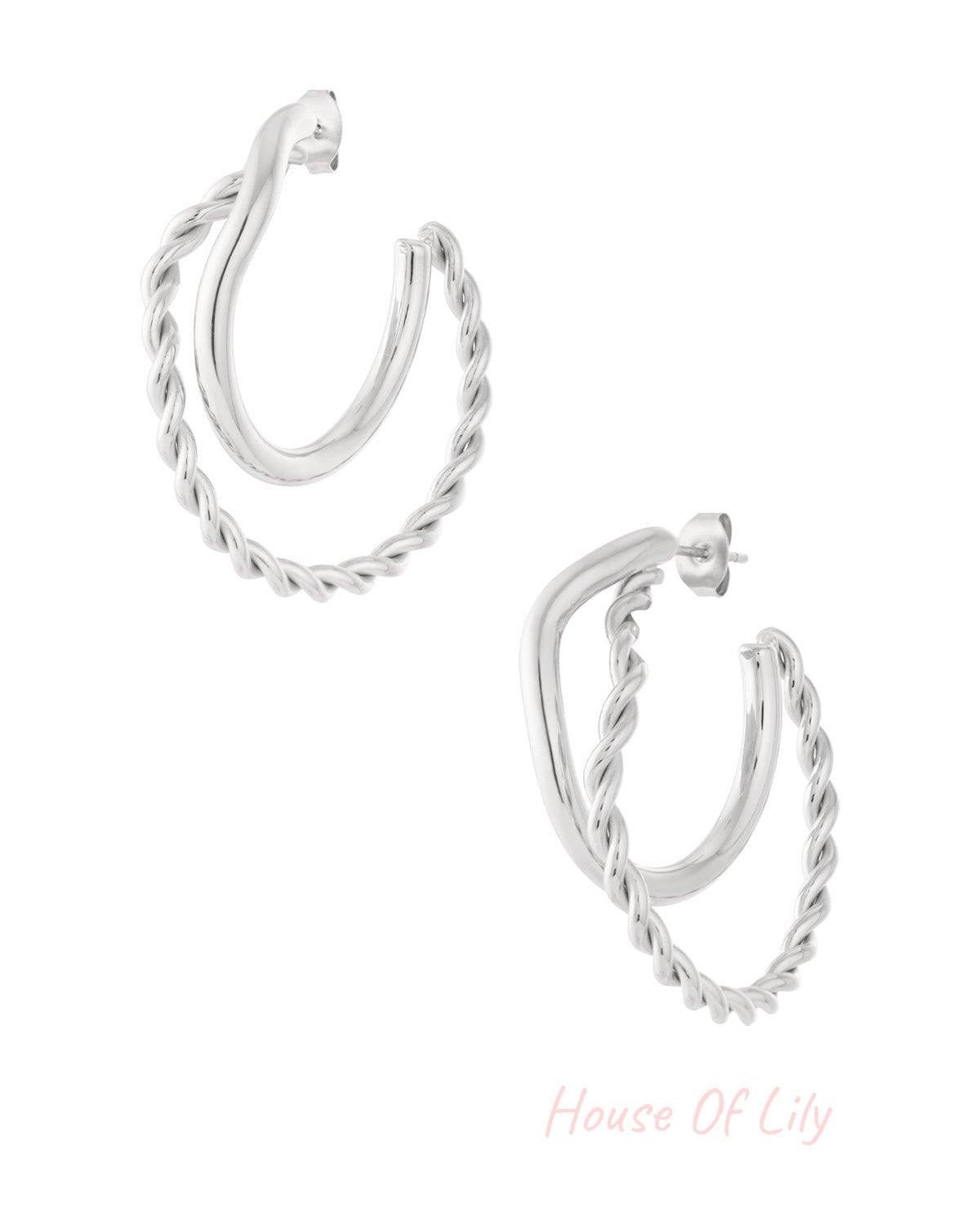 Pair of silver hoop earrings featuring one smooth and one twisted braided hoop, studio white background