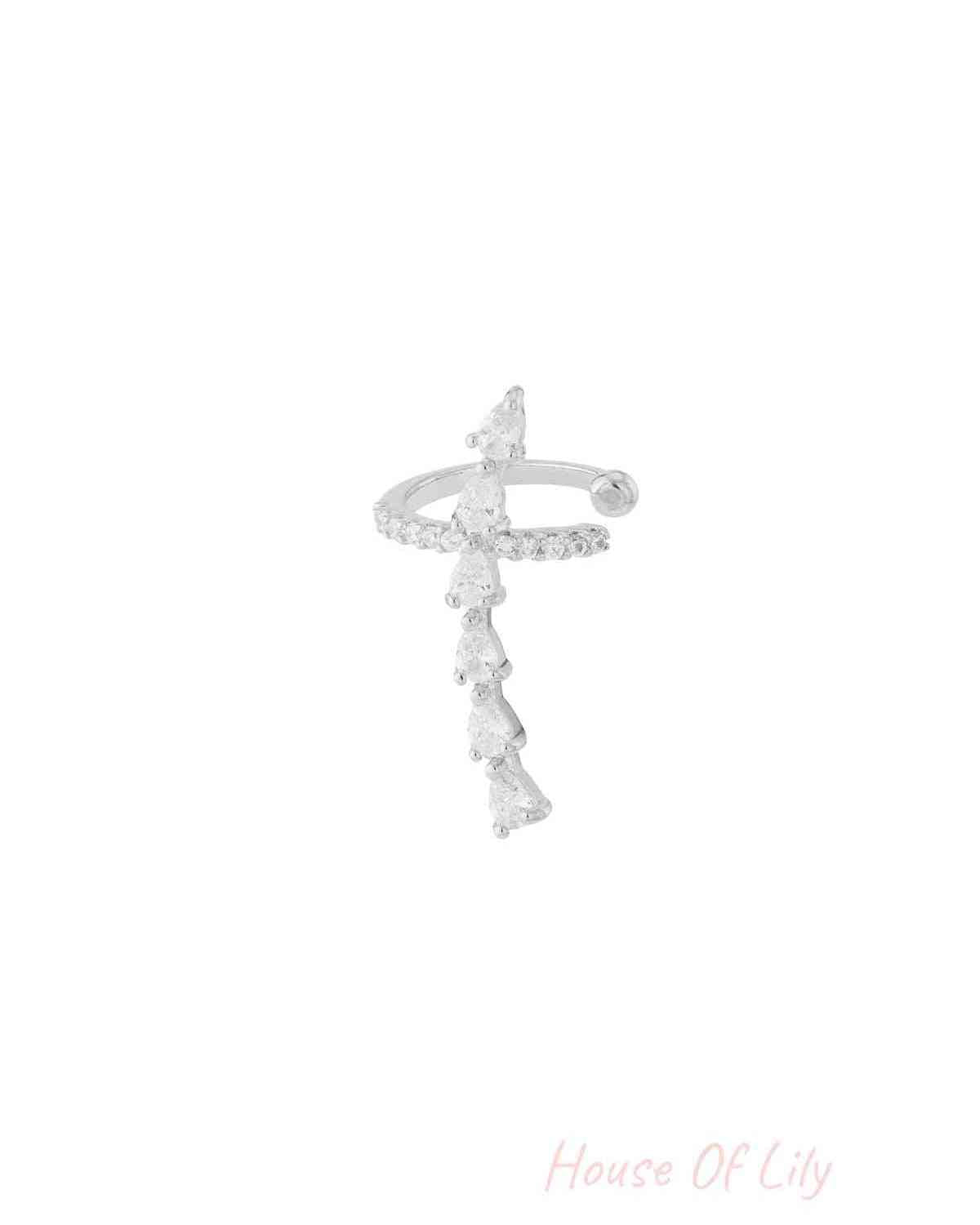 Silver tone ear cuff with cascading pear-shaped cubic zirconia stones on a white background