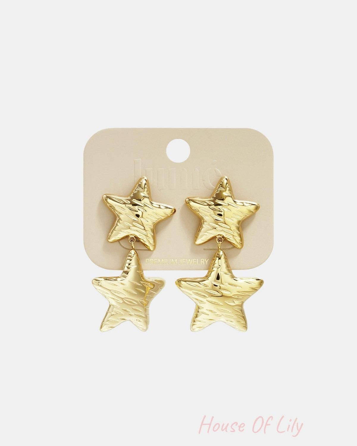 Gold star-shaped double drop earrings displayed on light beige jewelry card labeled 'Lumé Premium Jewelry'