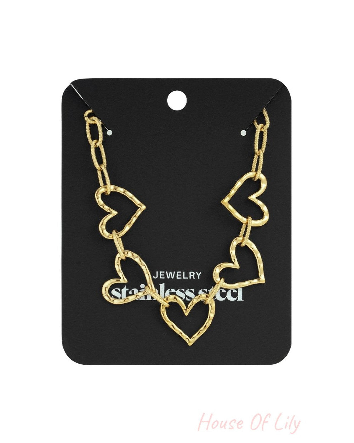 Gold-tone stainless steel heart-link chain necklace on a black display card.