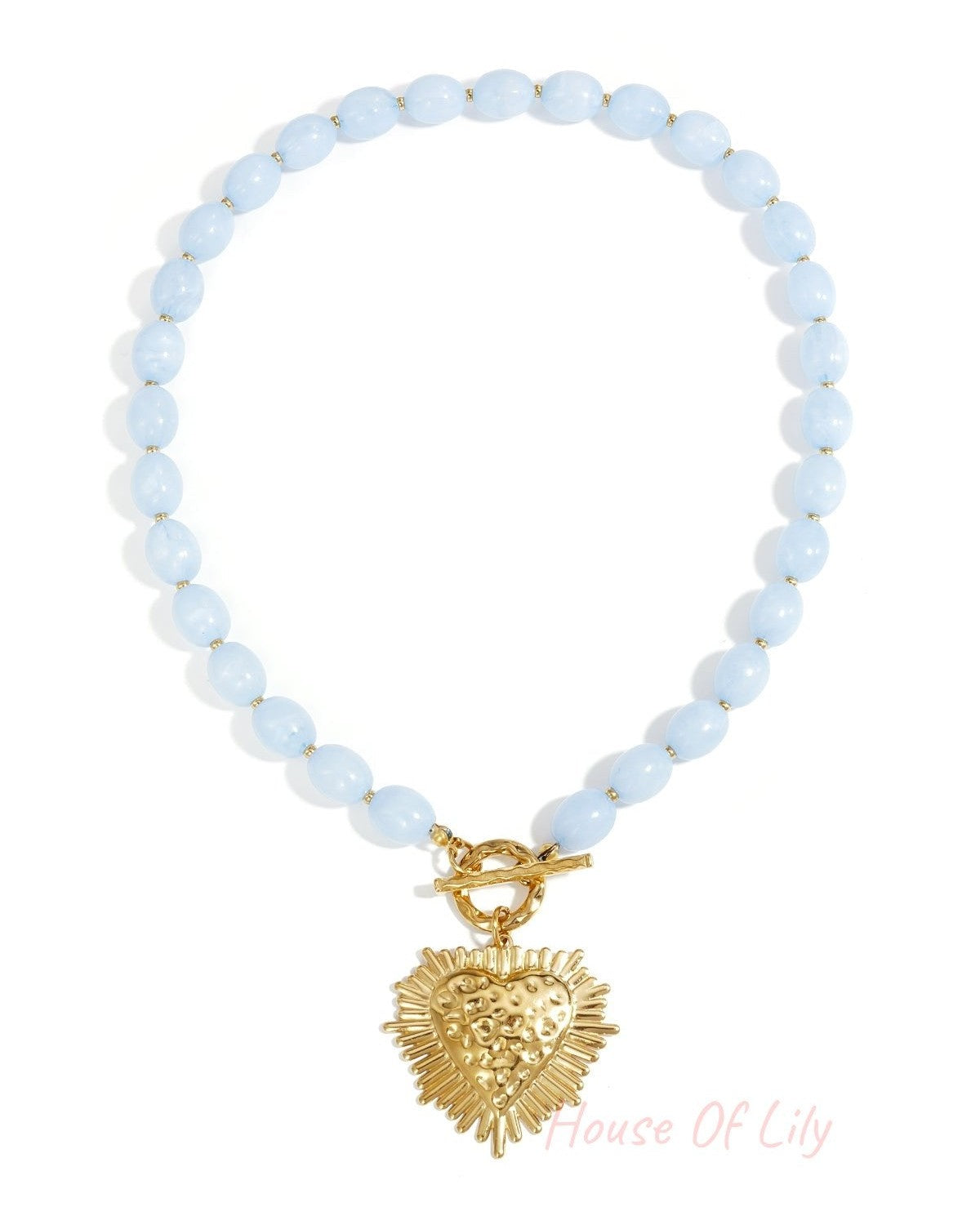 Necklace with light blue oval beads, gold toggle clasp, and a textured, sunburst-style gold heart pendant.