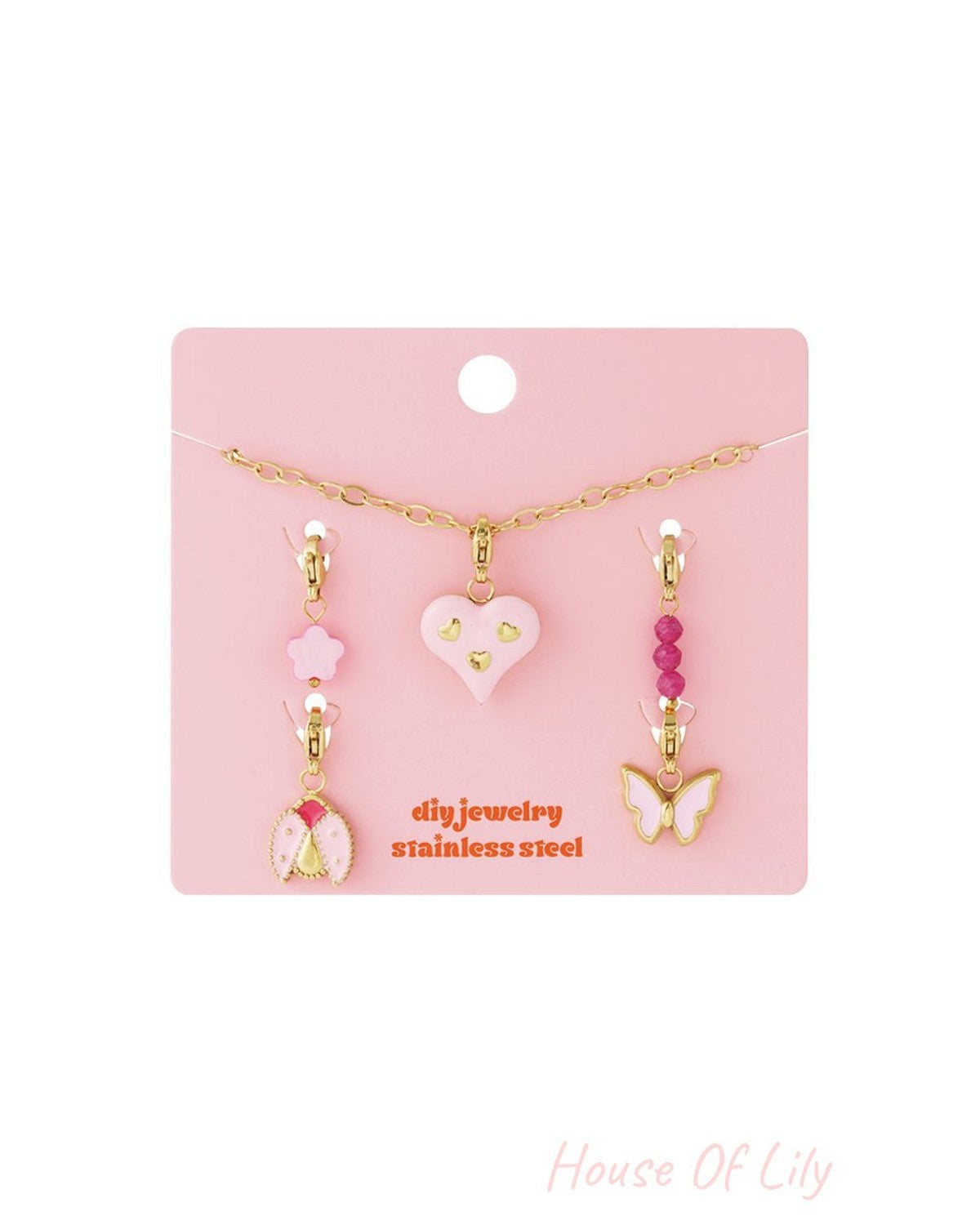 Your Custom Vibe: Gold-tone stainless steel DIY jewelry set with a pink heart, butterfly, and ladybug charms on a card.