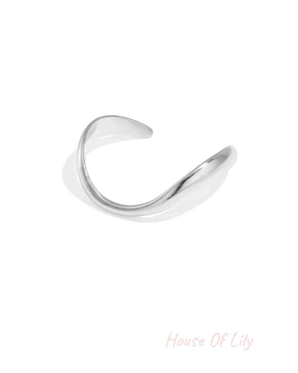 Silver-toned organically sculpted open cuff bracelet with smooth curved design on white background