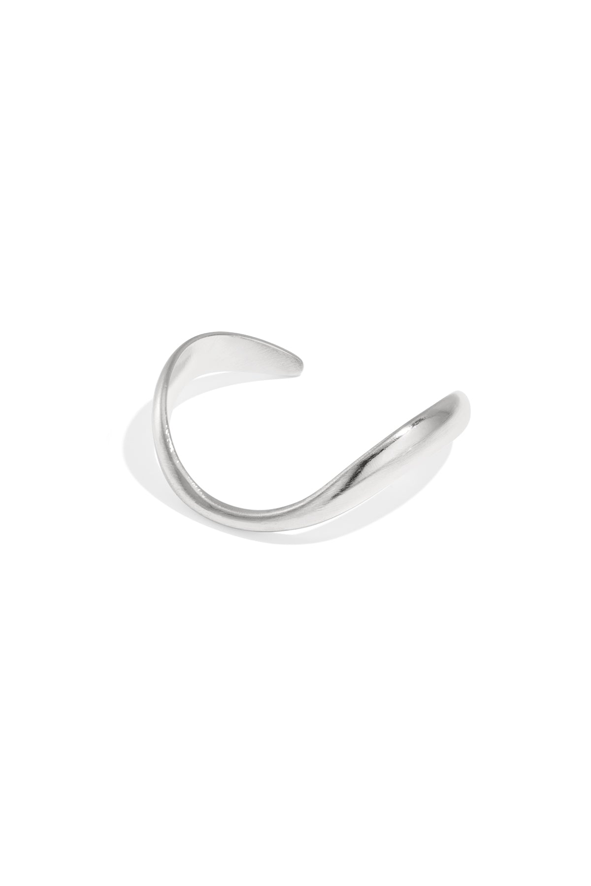 Silver-toned organically sculpted open cuff bracelet with smooth curved design on white background