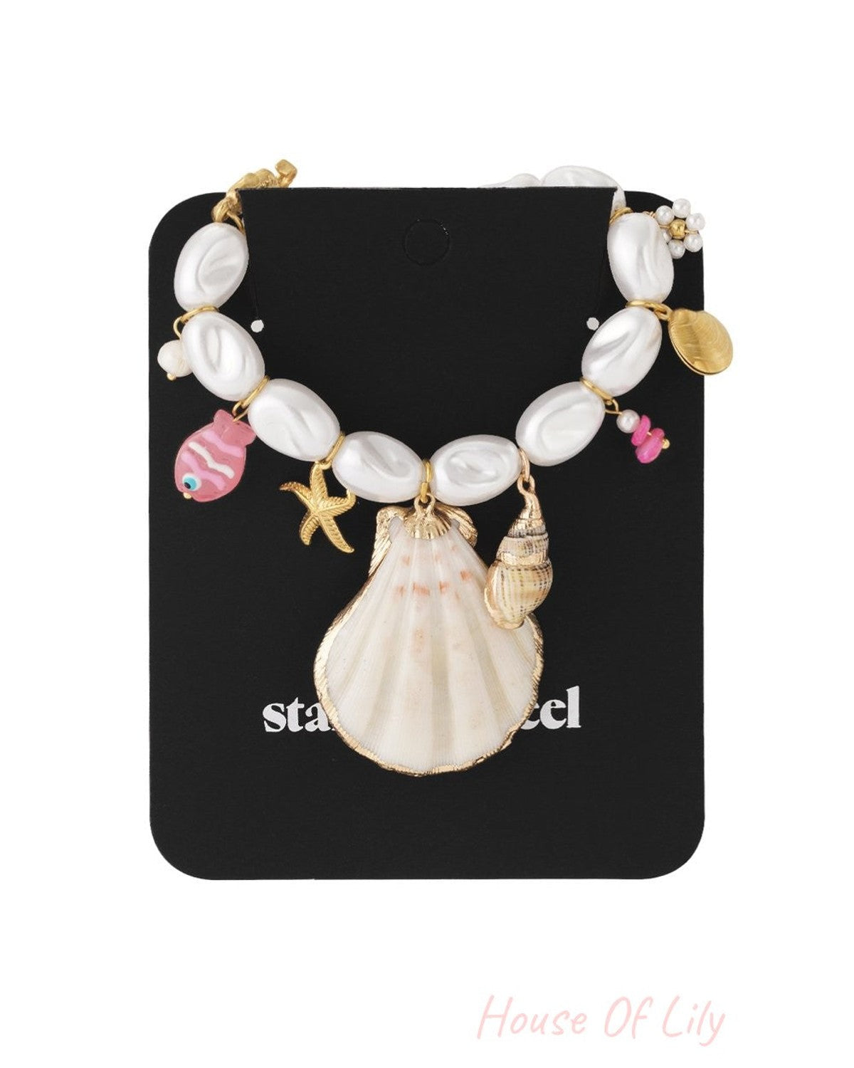 Nautical necklace with white oval pearls, a large seashell charm, and colorful fish and starfish accents on gold chain.