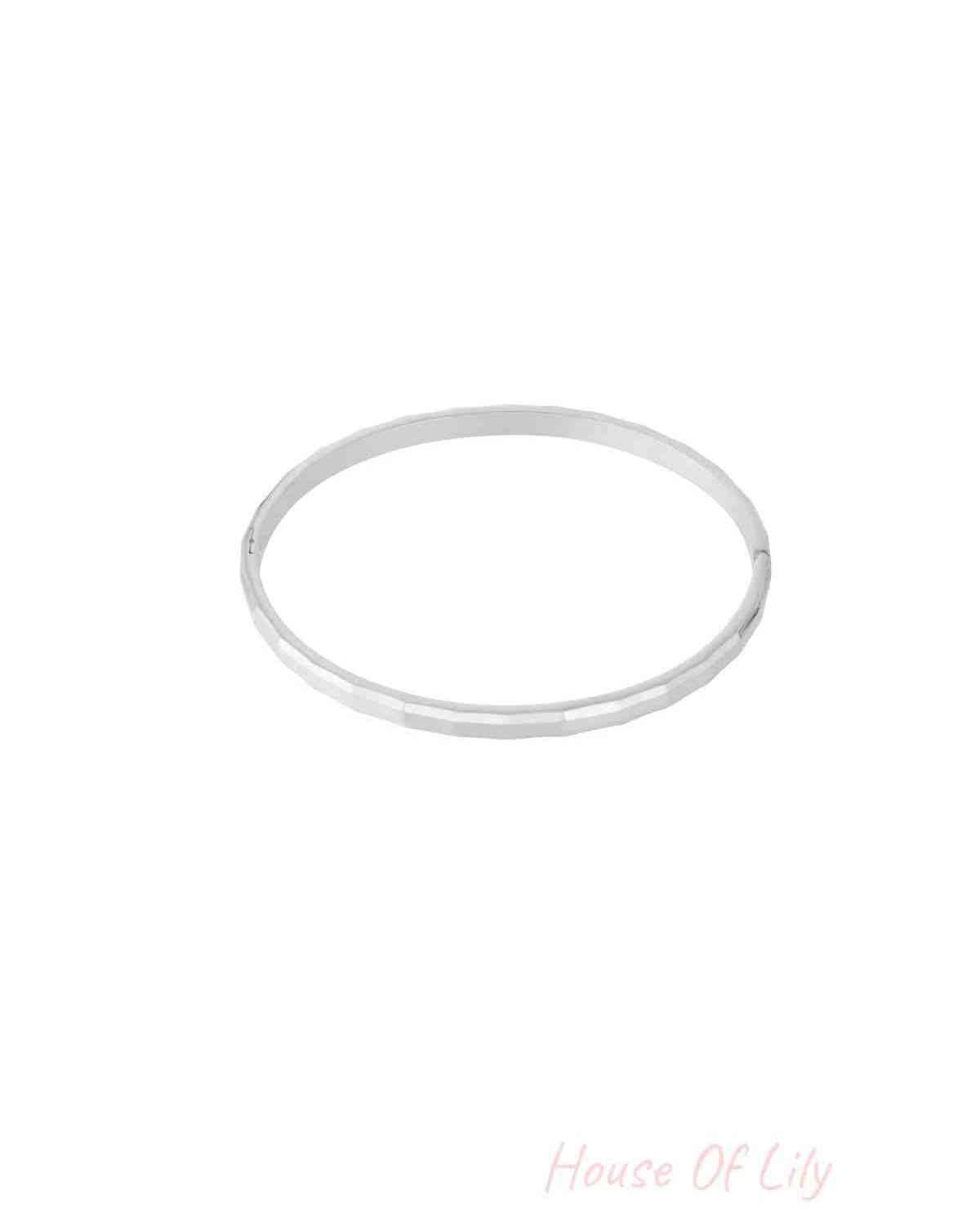 Single geometric faceted silver bangle isolated on white background