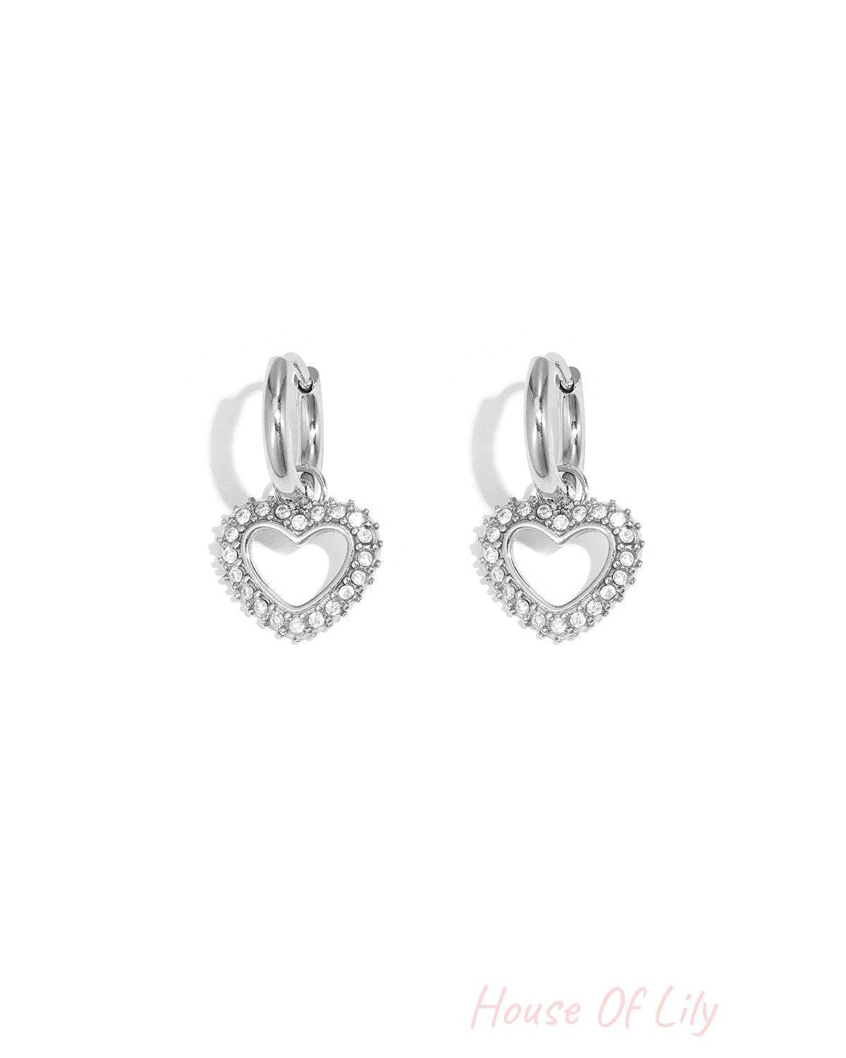 Silver-tone heart-shaped rhinestone drop earrings with smooth hoop closure on white background