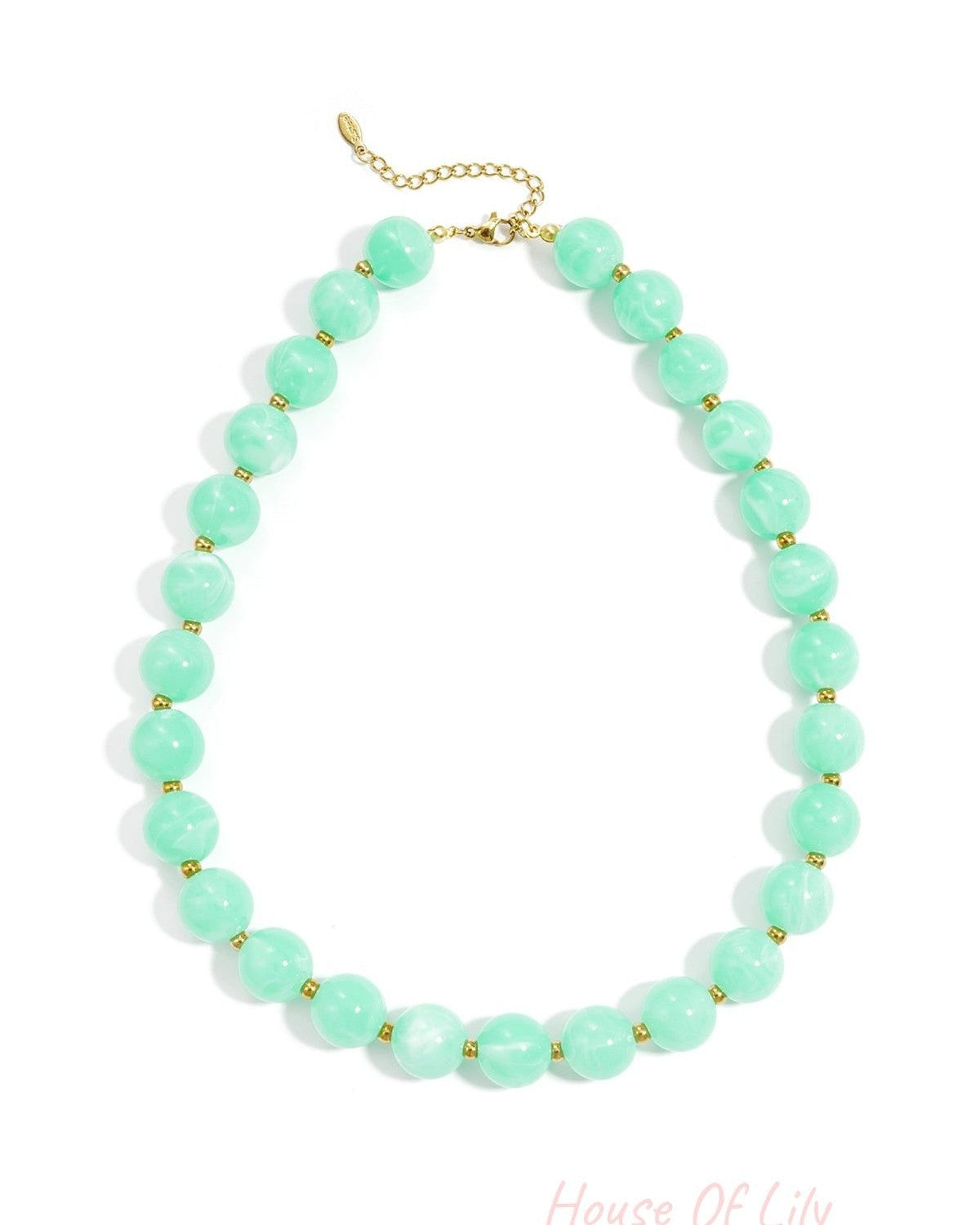 A statement necklace featuring large, round, mint green marbled beads separated by small gold spacers on a gold chain.