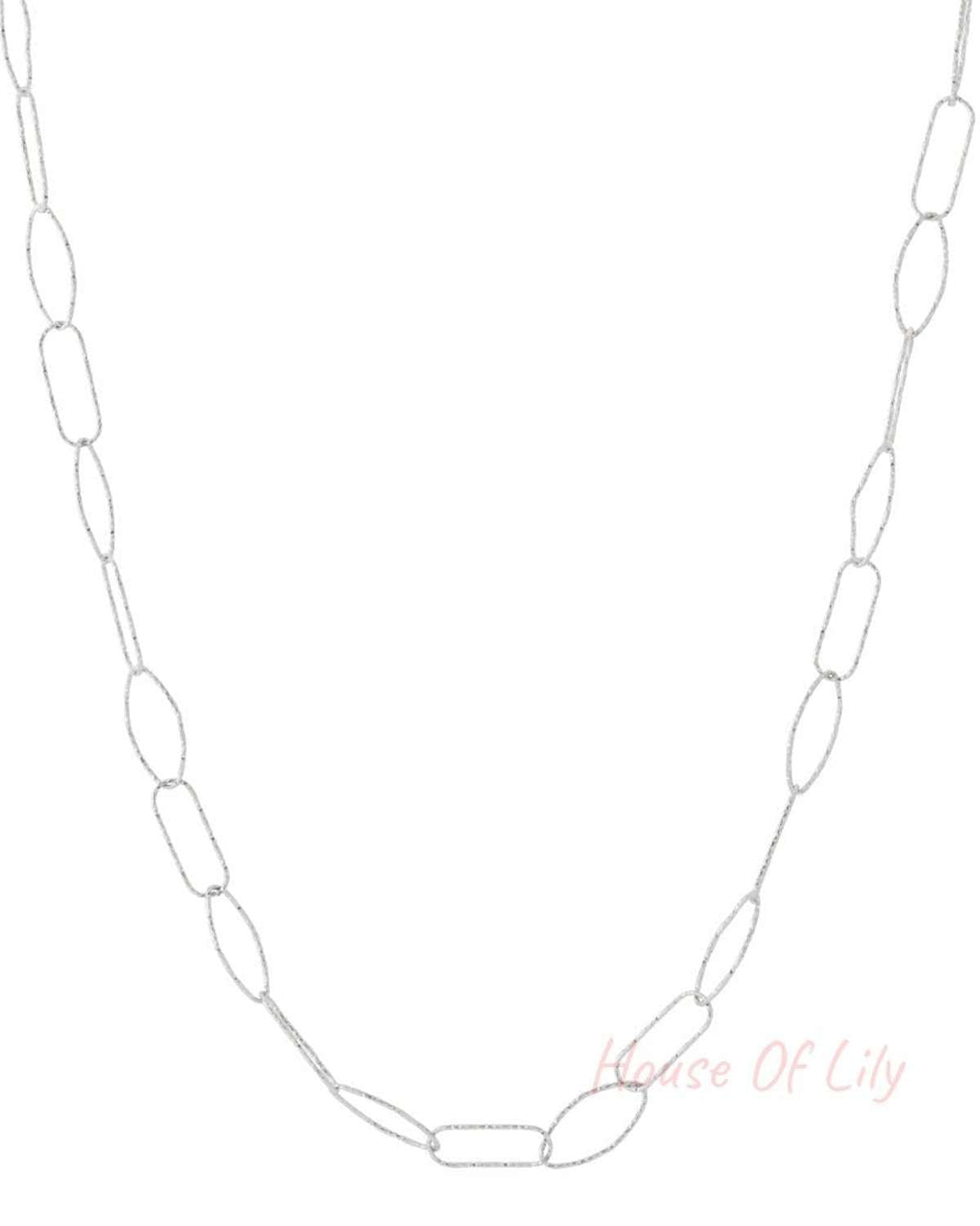 Close-up of silver textured link chain necklace with alternating oval and rectangular links on white background