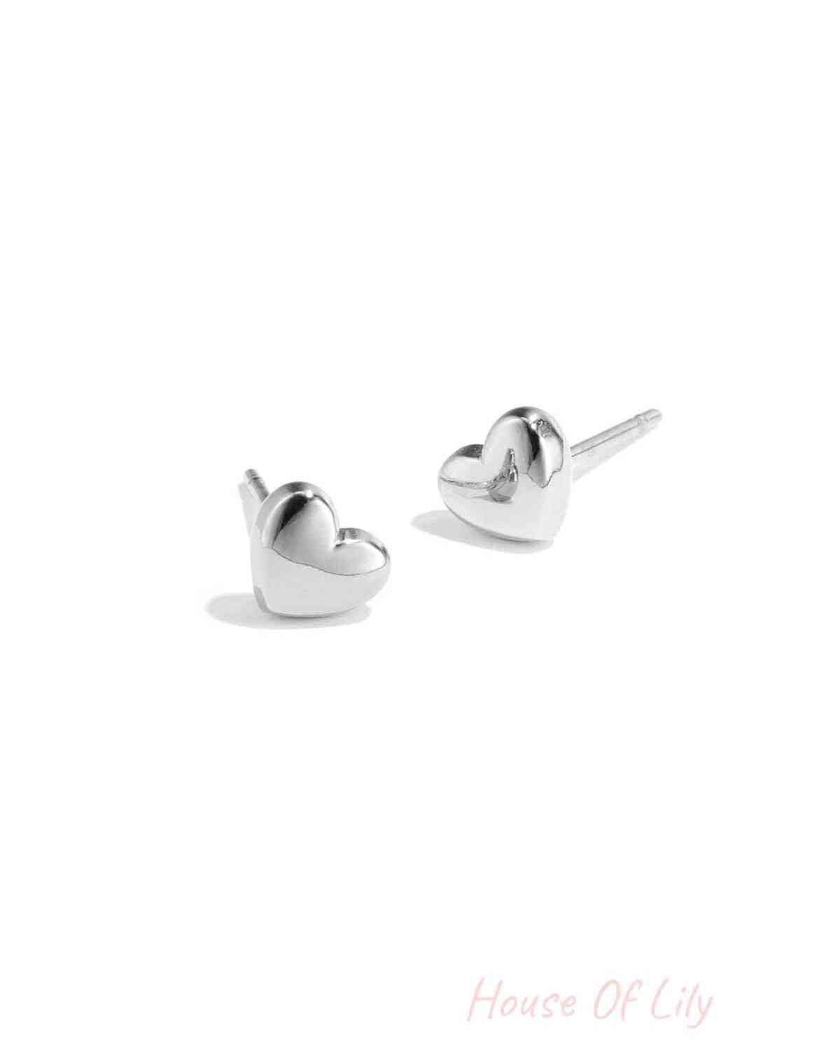 Pair of polished silver heart-shaped stud earrings on white background