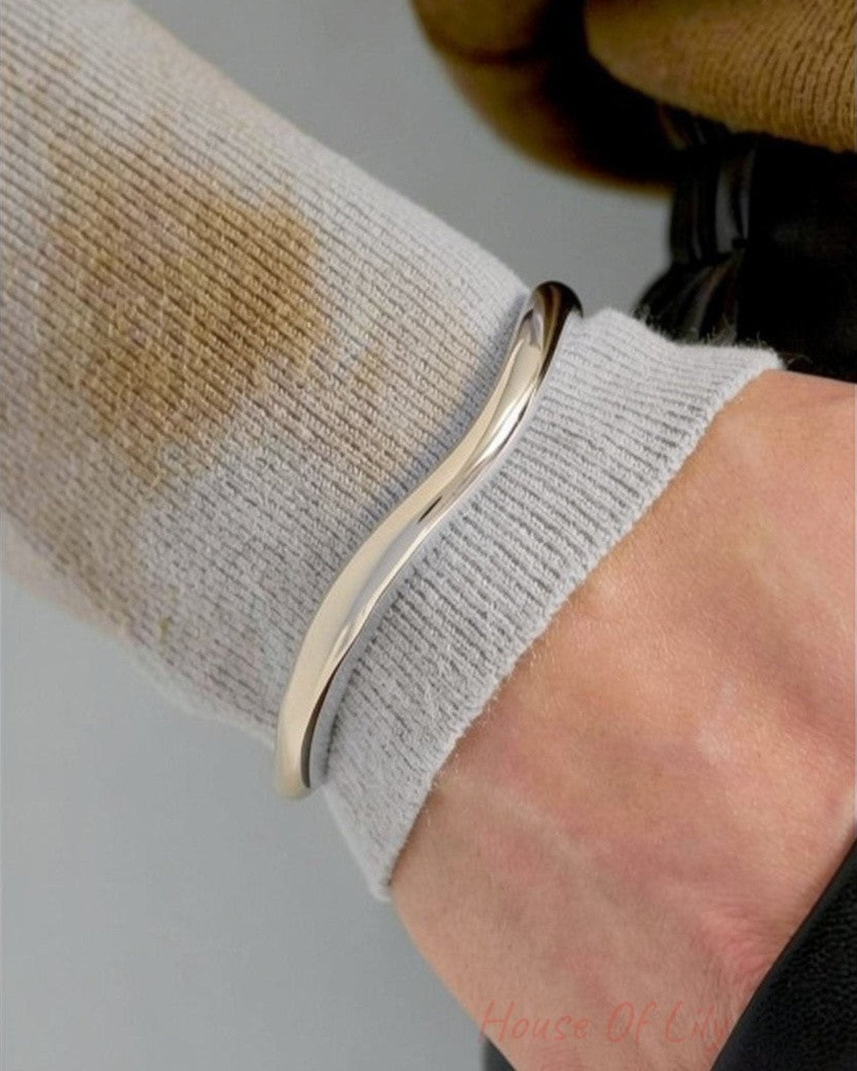 Clean Aesthetic Cuff: A minimalist, polished silver-tone metal cuff with a smooth, fluid, wavy organic shape.