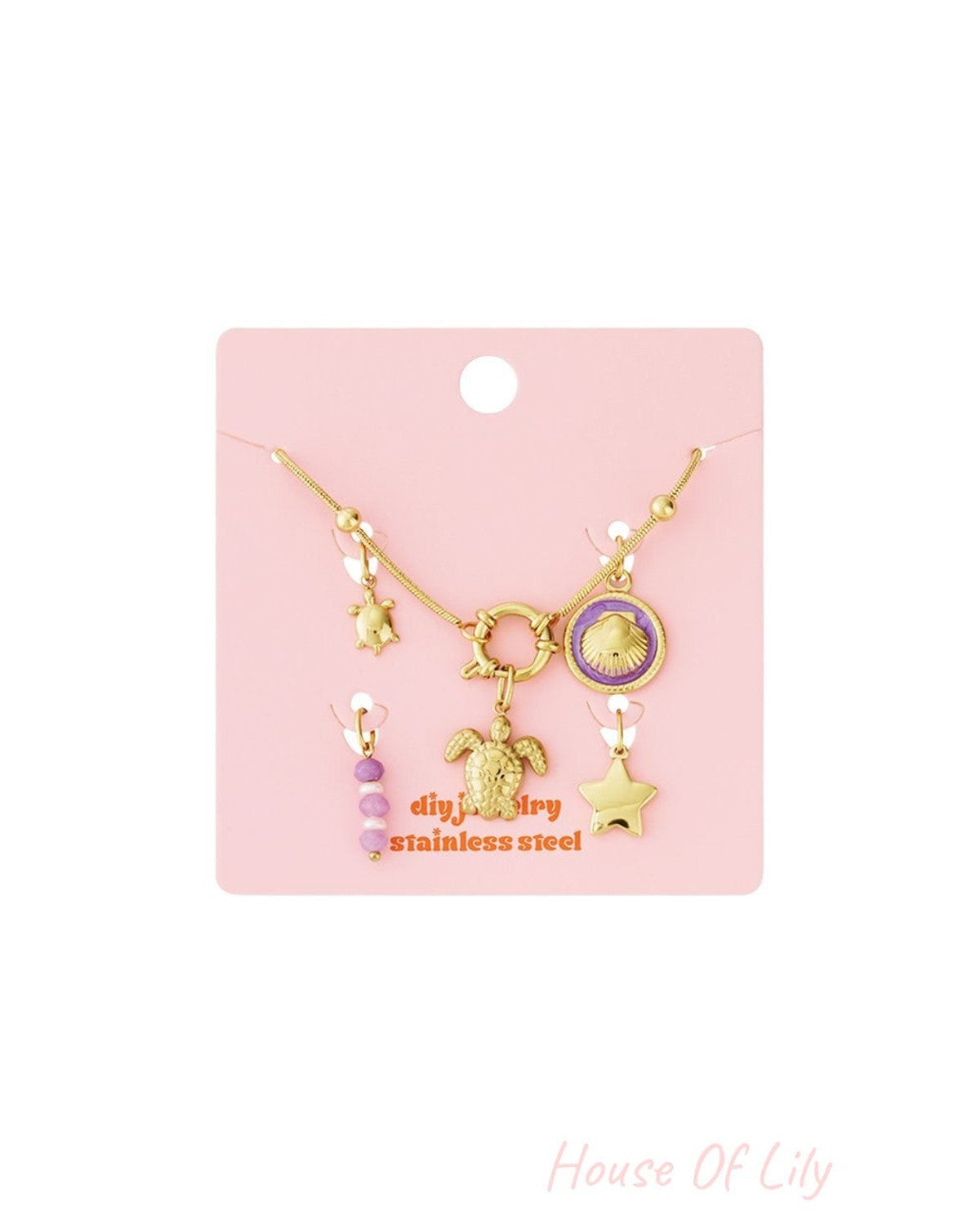 Gold stainless steel charm set on pink card, featuring turtle, seashell, star charms, and purple beaded accents.