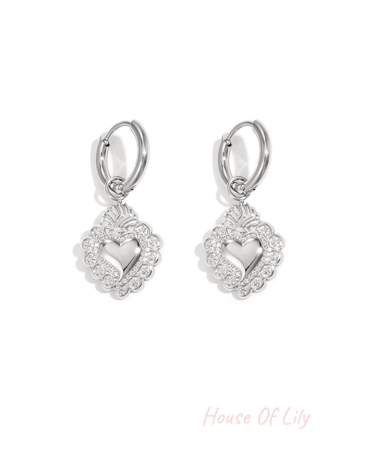 Pair of silver-toned hoop earrings with the same ornate heart-shaped pendants, highlighting polished finish and detailed design