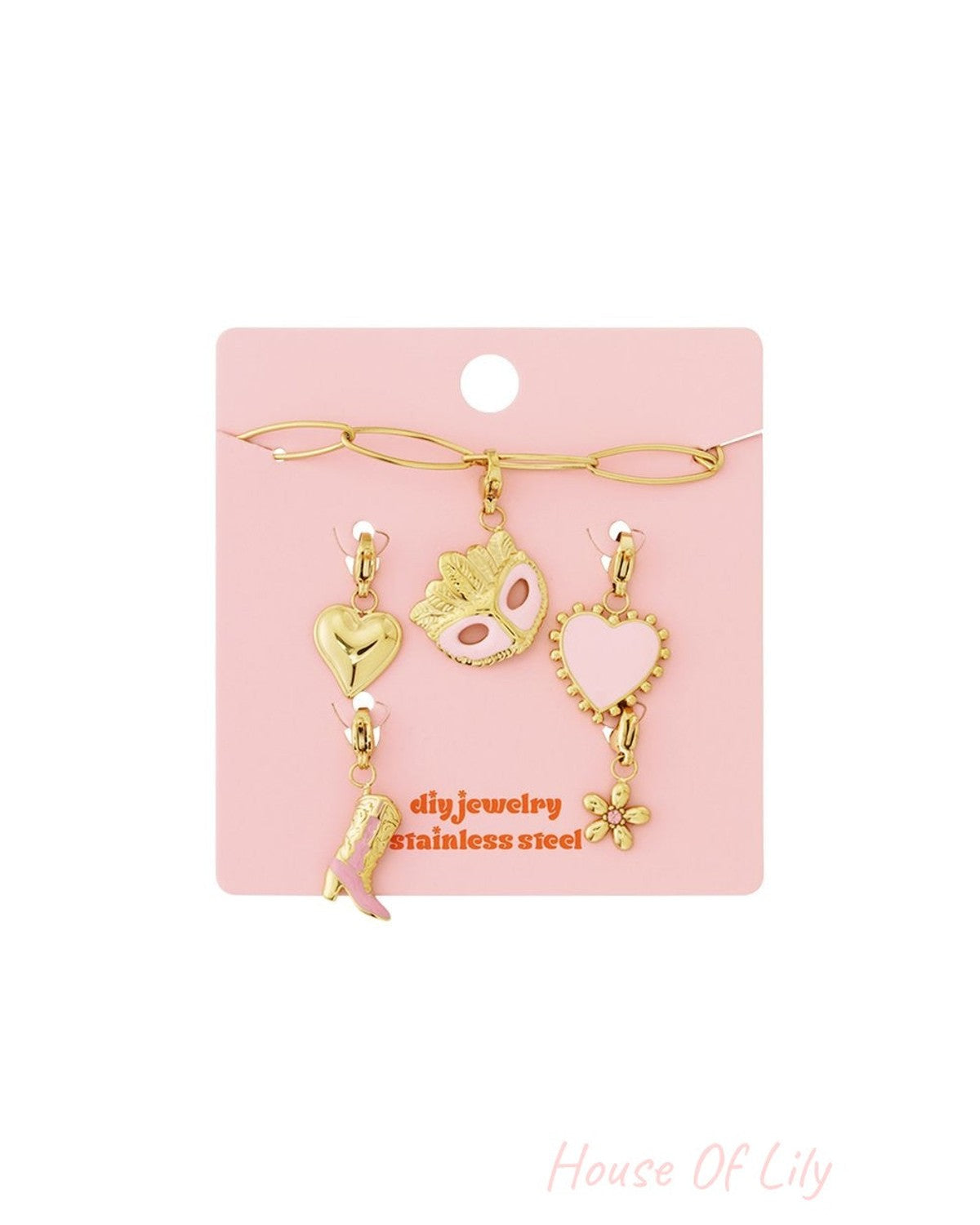 Gold stainless steel charm bracelet set with pink heart, mask, cowboy boot, and flower charms on a pink display card.