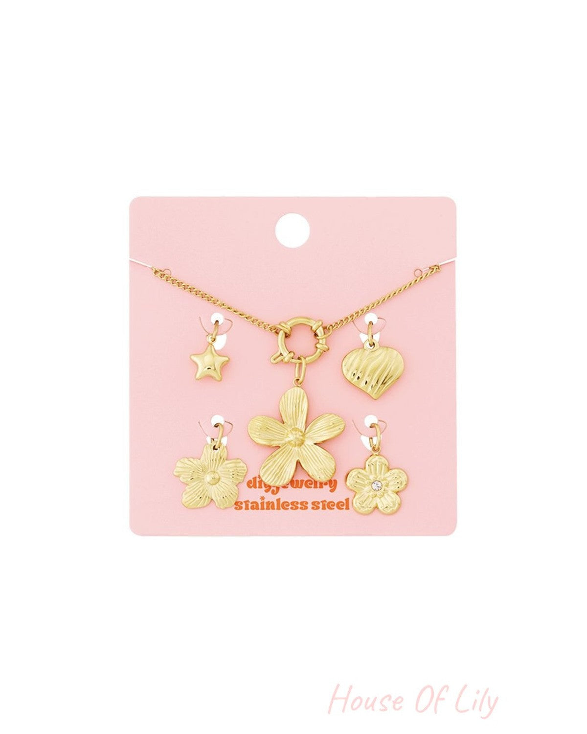 Radiant Crystal Charm Bracelet in gold-tone stainless steel with star, heart, and flower charms on a pink display card.