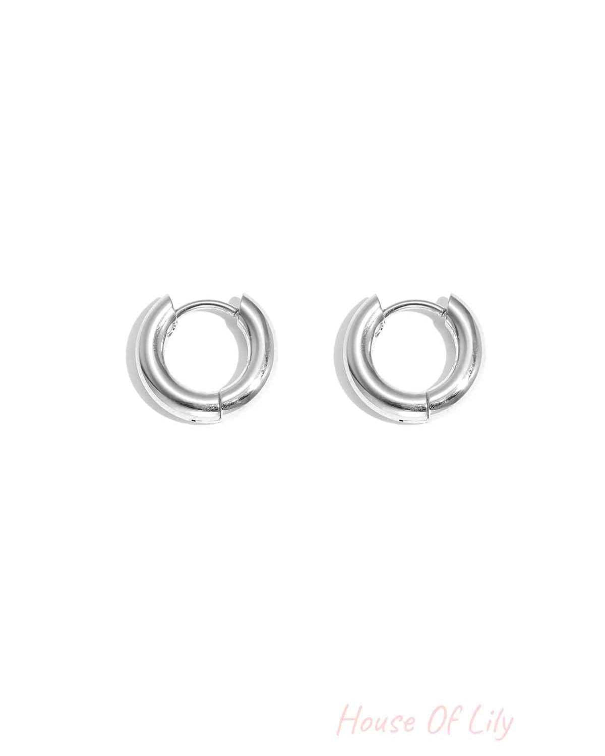 Pair of chunky silver hoop earrings with smooth polished finish on white background