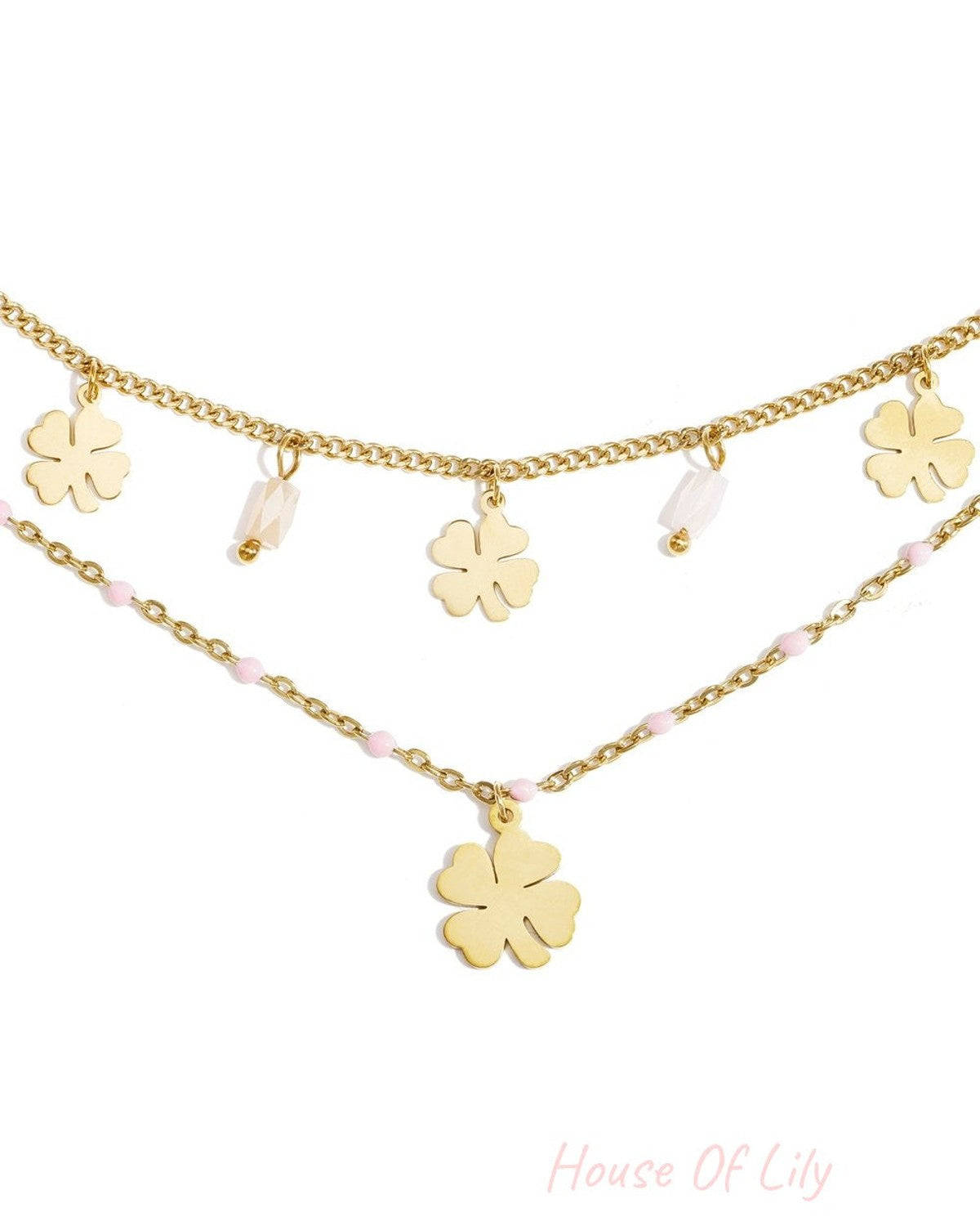 Elegant gold layered chain bracelet featuring dangling four-leaf clover charms, white beads, and small pink accents.