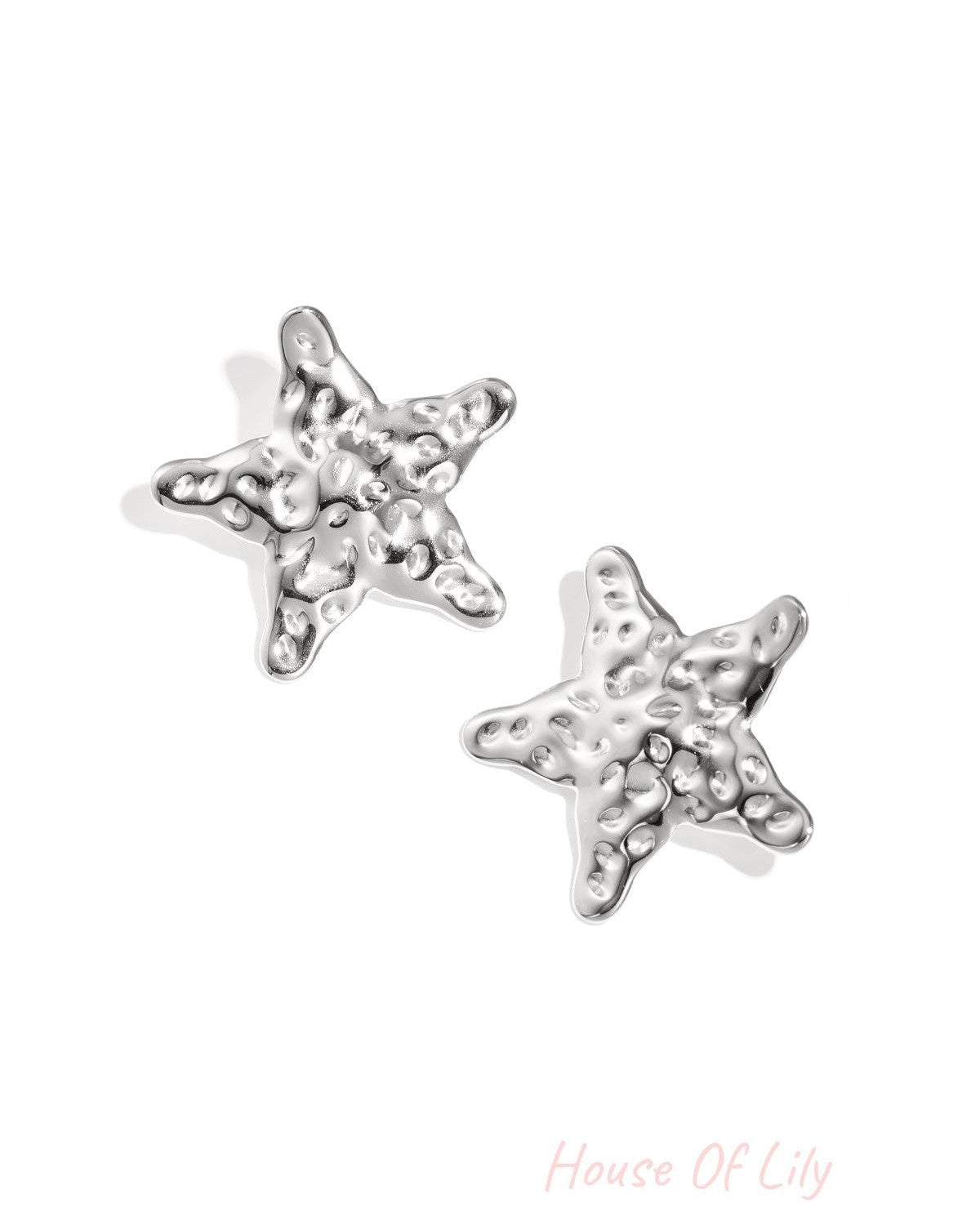 Close-up view of silver textured starfish-shaped stud earrings on white background