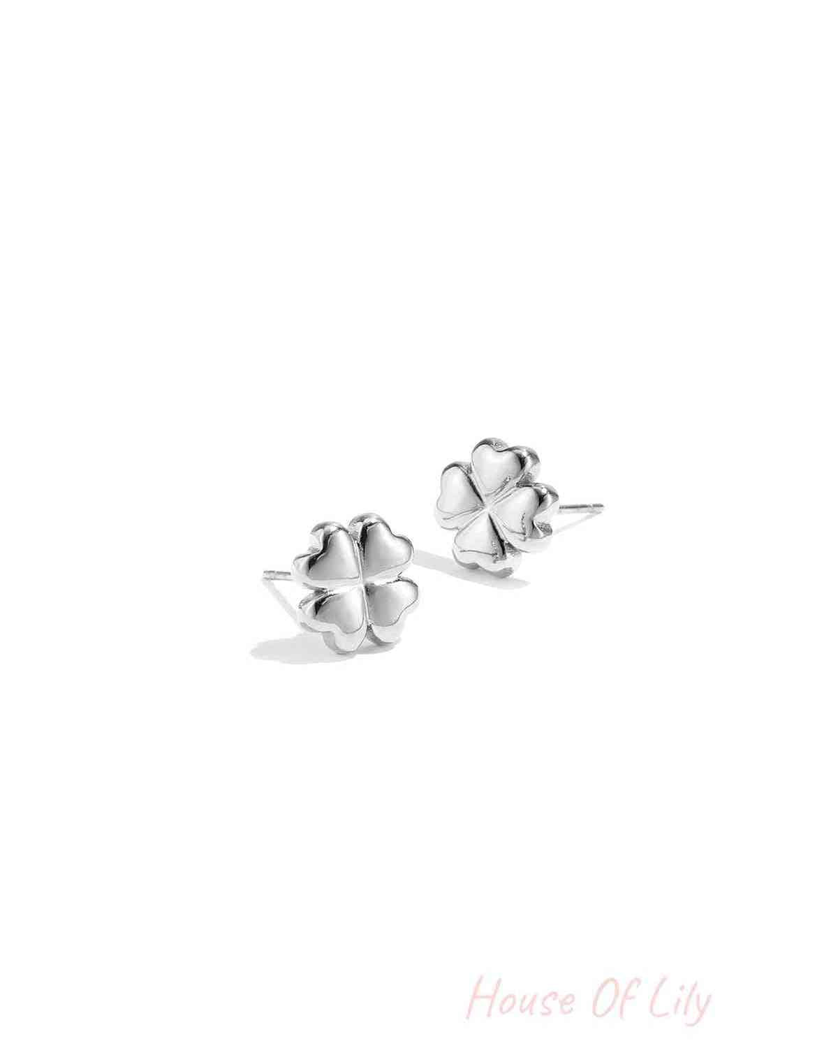 Pair of shiny silver four-leaf clover stud earrings on white background