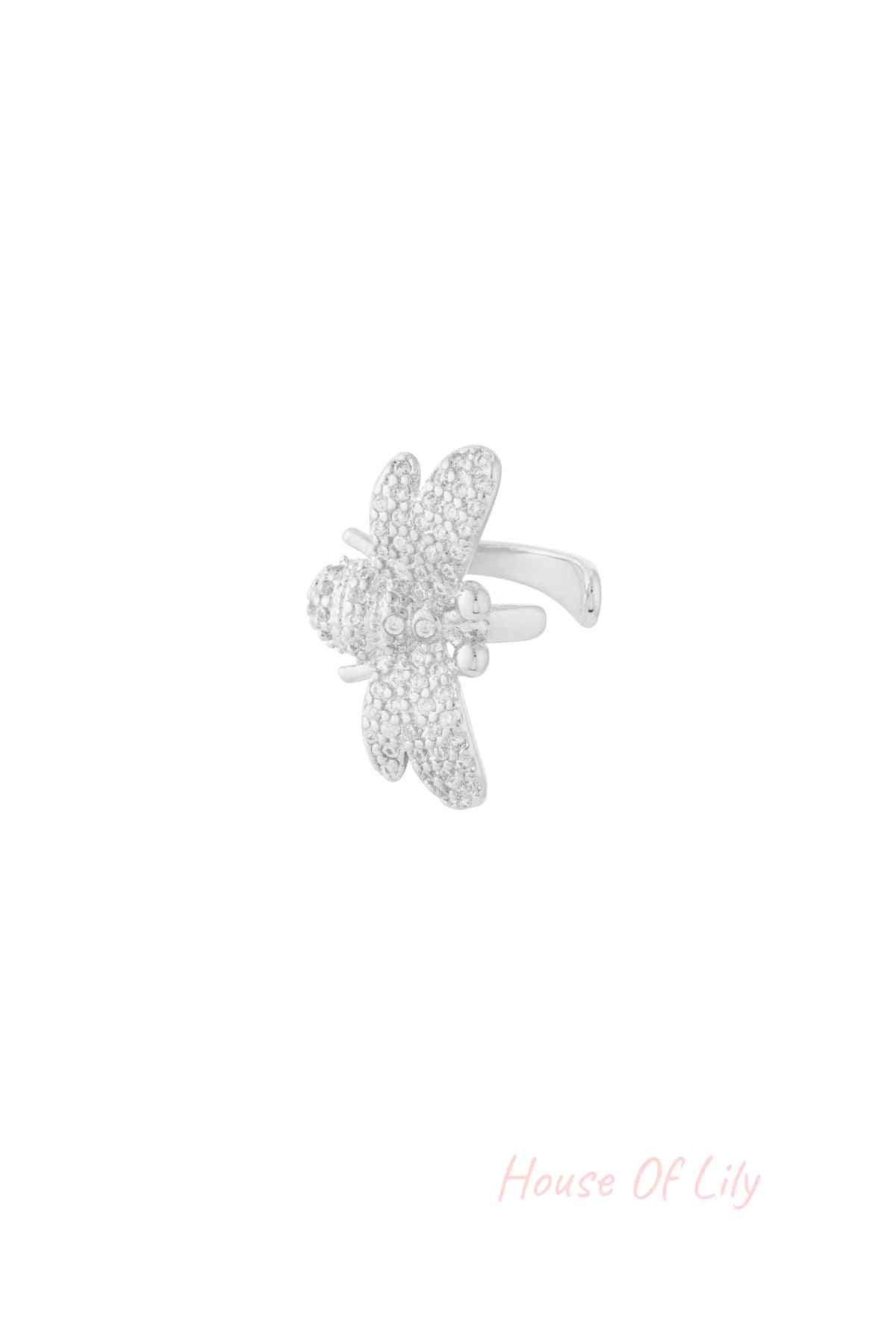 Close-up image of a silver ear cuff shaped like a bee with sparkling zircon crystals