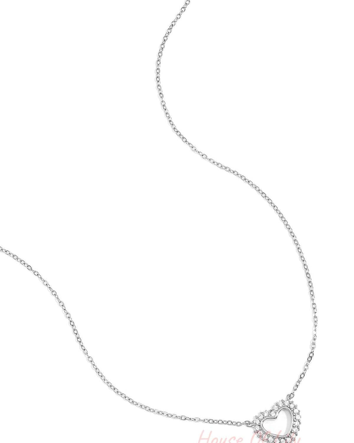 Silver heart-shaped pendant necklace with rhinestones on a delicate silver chain displayed on white background