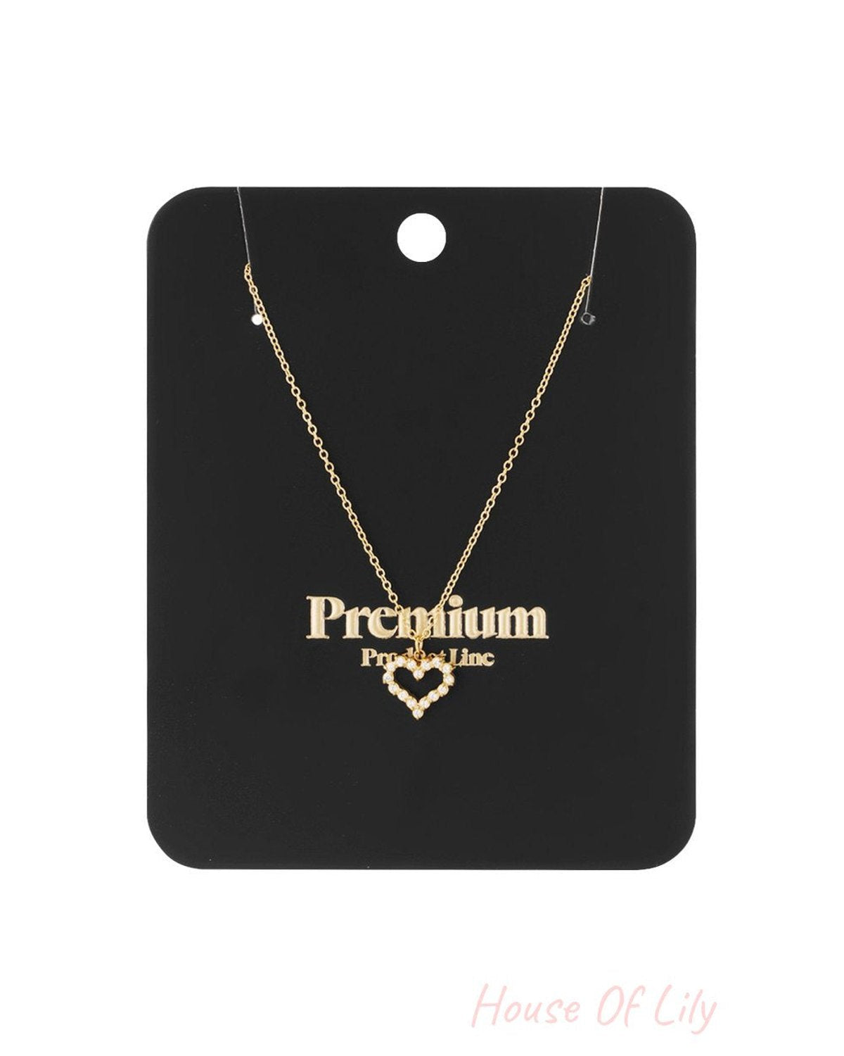 Gold-tone chain necklace with a small heart-shaped pendant outlined in clear, sparkling rhinestones.