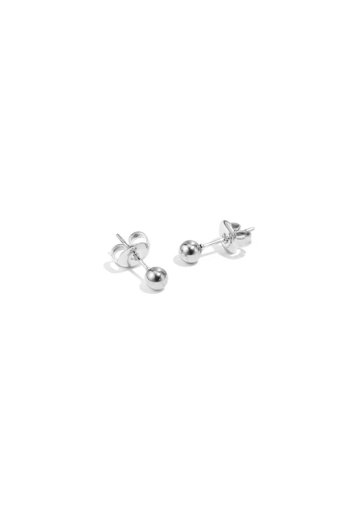 Pair of shiny silver dot stud earrings displayed on white surface