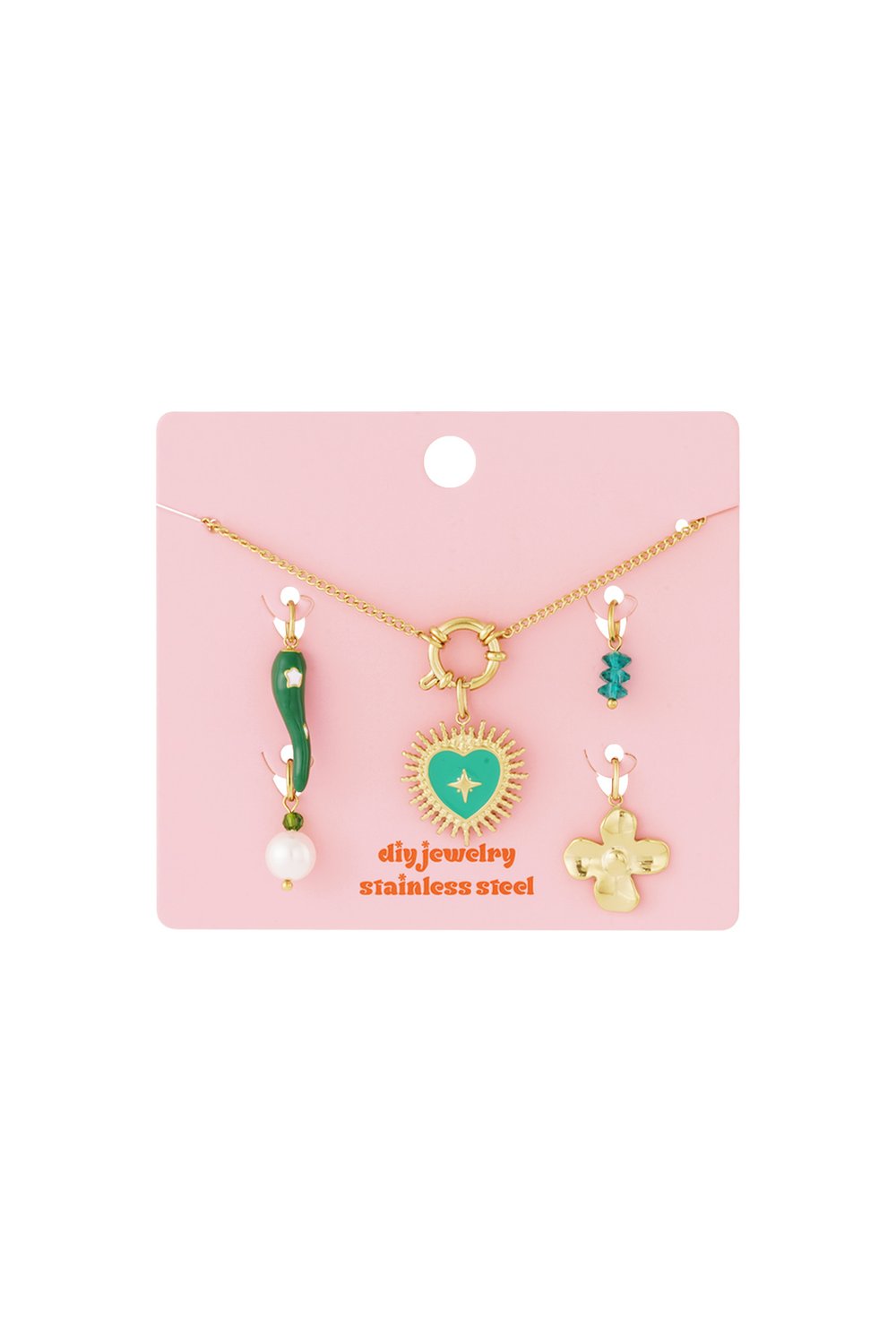 Gold stainless steel necklace with a green enamel heart charm and assorted decorative charms on a pink display card.