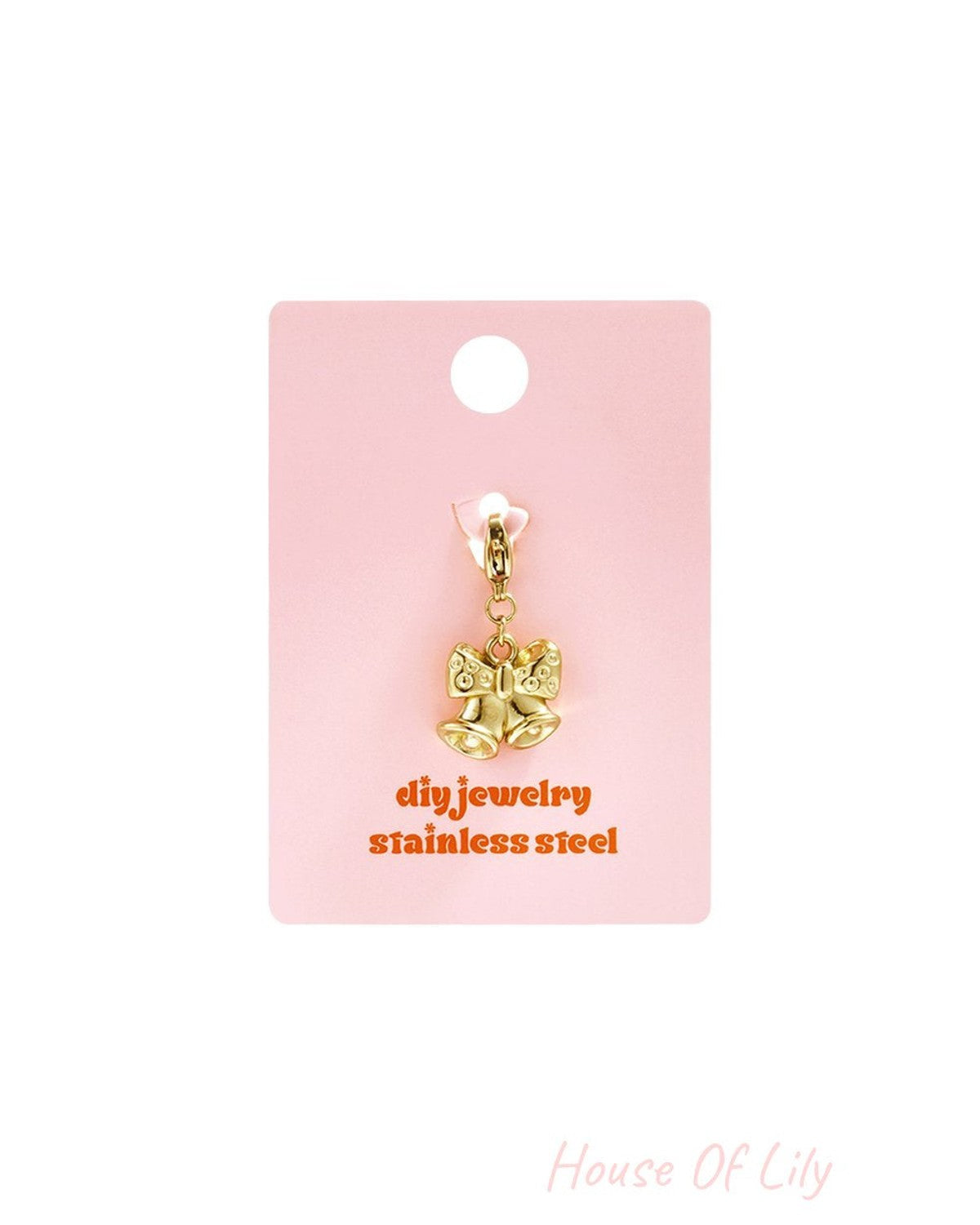 Golden bell charm with a bow, crafted from gold-tone stainless steel, displayed on a pink jewelry backing card.
