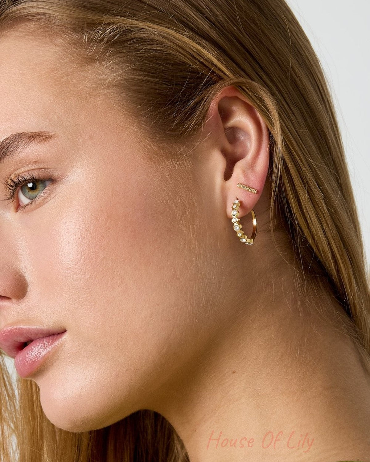 Glitch Beam gold stud earring featuring a slender, textured rectangular bar design worn on a model's ear.