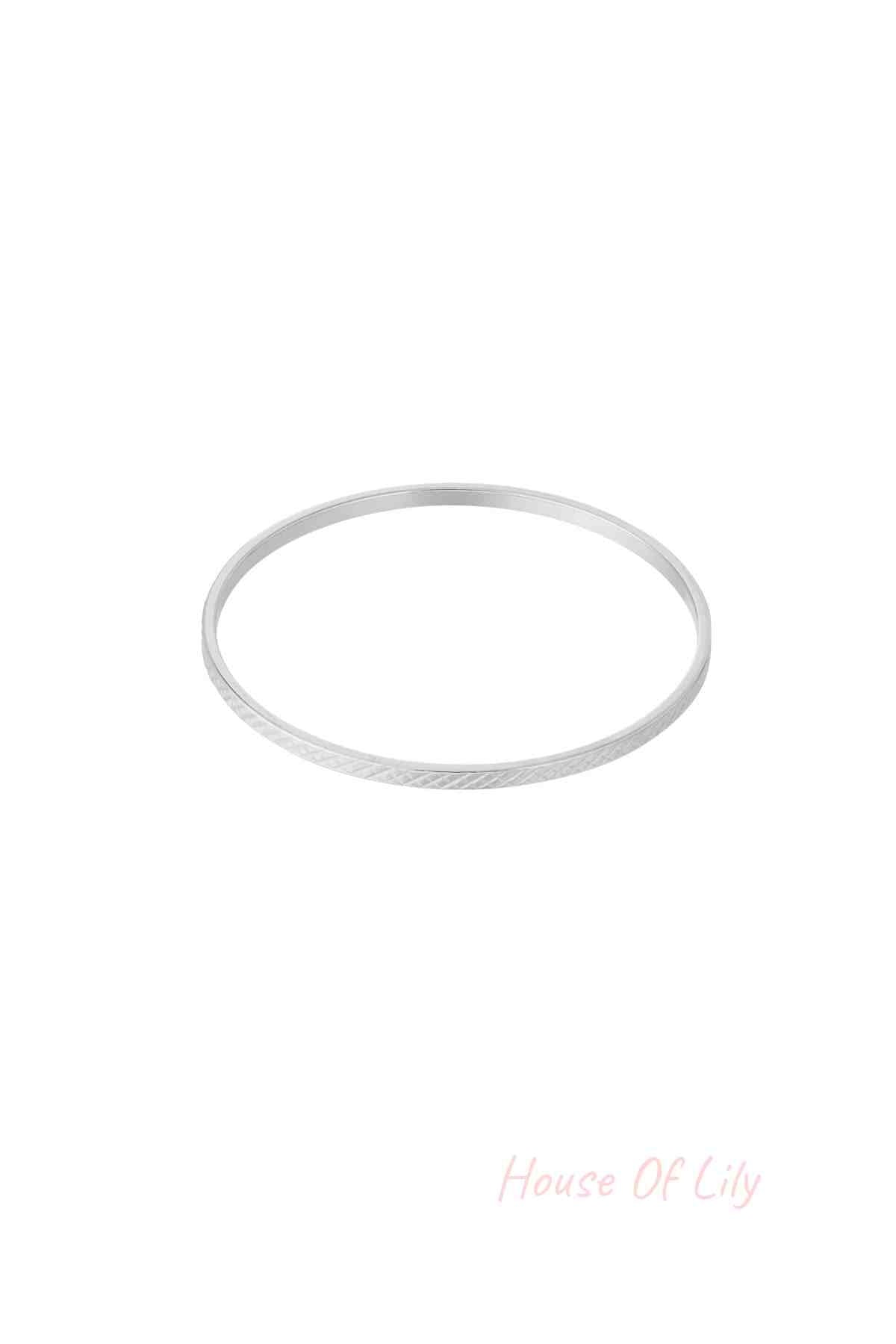Single slim silver-tone bangle with subtle crosshatch geometric pattern on white background